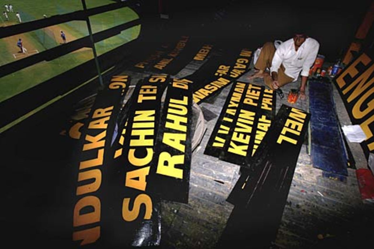 The scoreboard signwriter paints the names of the players ahead of the final Test, Mumbai, March 16, 2006