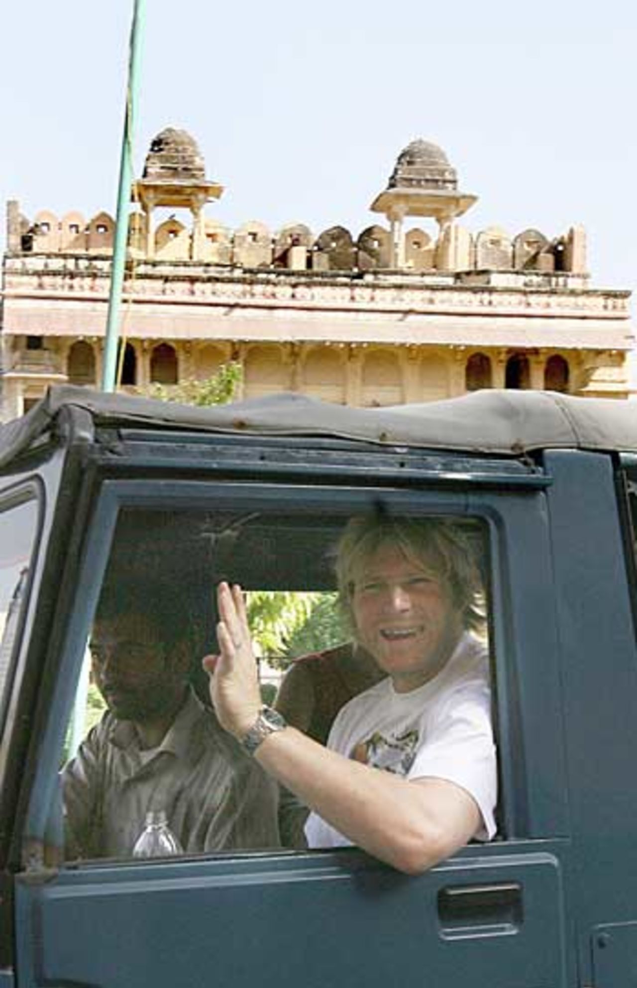 Matthew Hoggard waves from a jeep ahead of England's warm-up one-day match at Jaipur, March 24, 2006