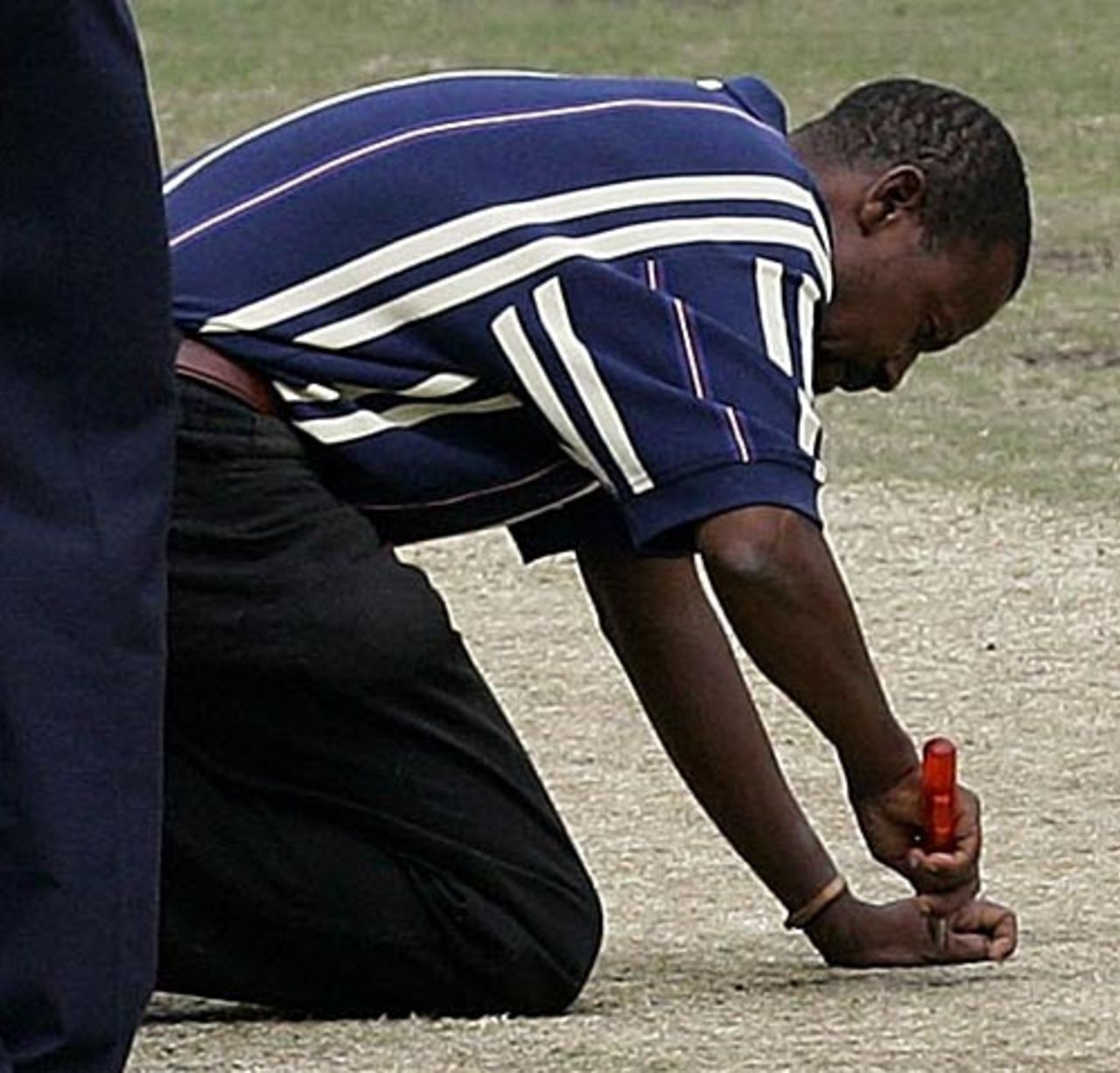 Groundman Wilson Ngoeese unrepairs a section of the pitch that had been illegally repaired overnight, South Africa v Australia, 2nd Test, Durban, March 27, 2006