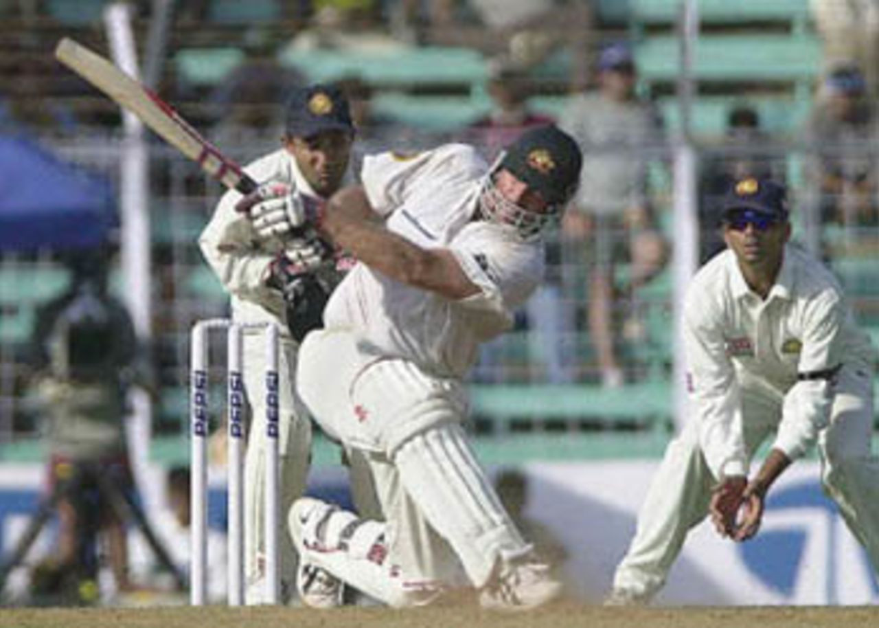 Australian batsman Matthew Hayden (C) hits a six as Indian wicketkeeper Nayan Mongia (L) and Indian player Rahul Dravid look on during the first day's play of the first Test match between India and Australia at Wankhade stadium in Bombay, 27 February 2001. Hayden remained unbeaten on 24 runs as Australia finished the day at 49 for 1 in reply to India's 176.