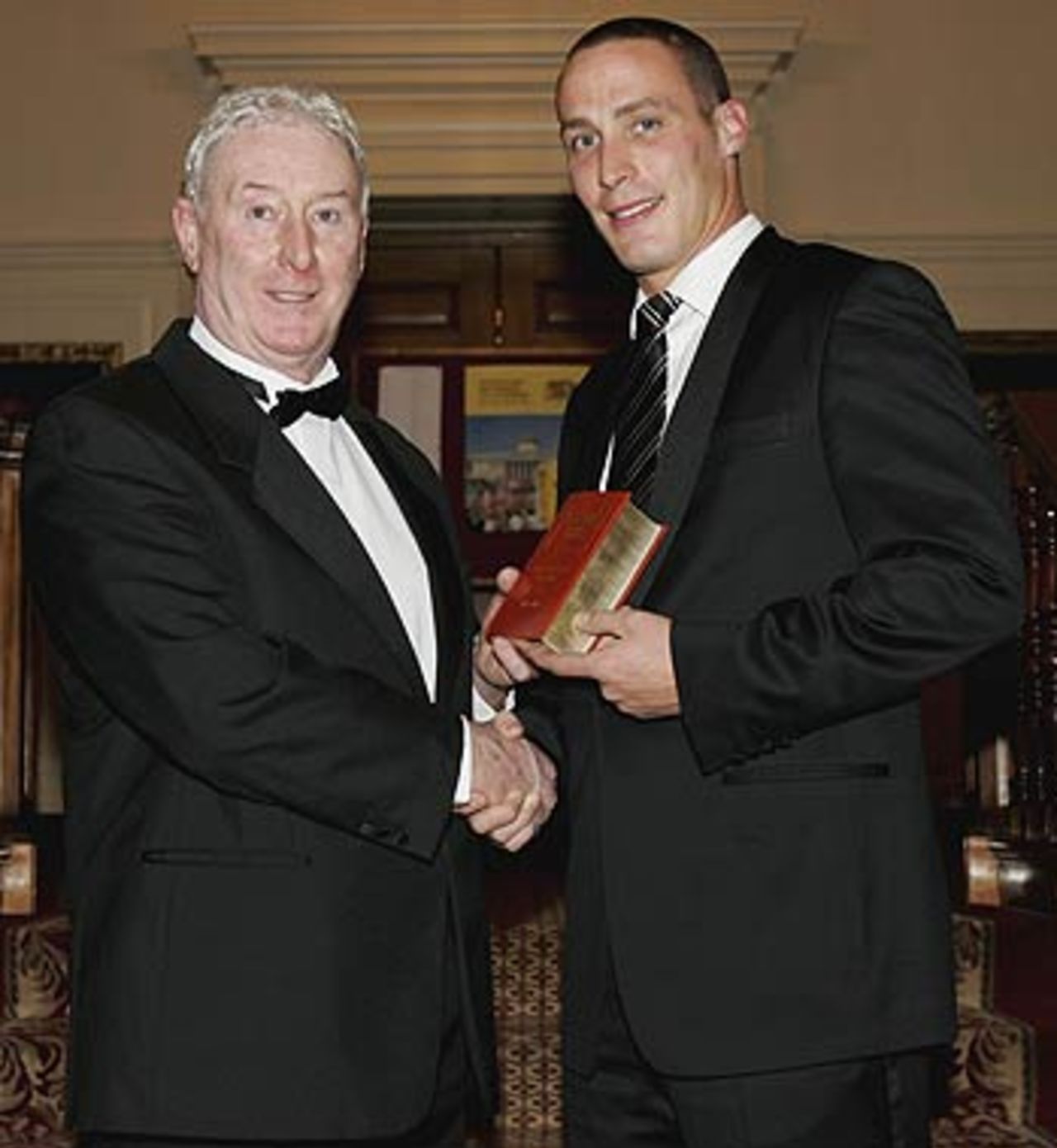 Simon Jones is presented with the Wisden Cricketer of the Year award by his father, Jeff Jones during the Wisden 2006 launch, London, April 11 2006