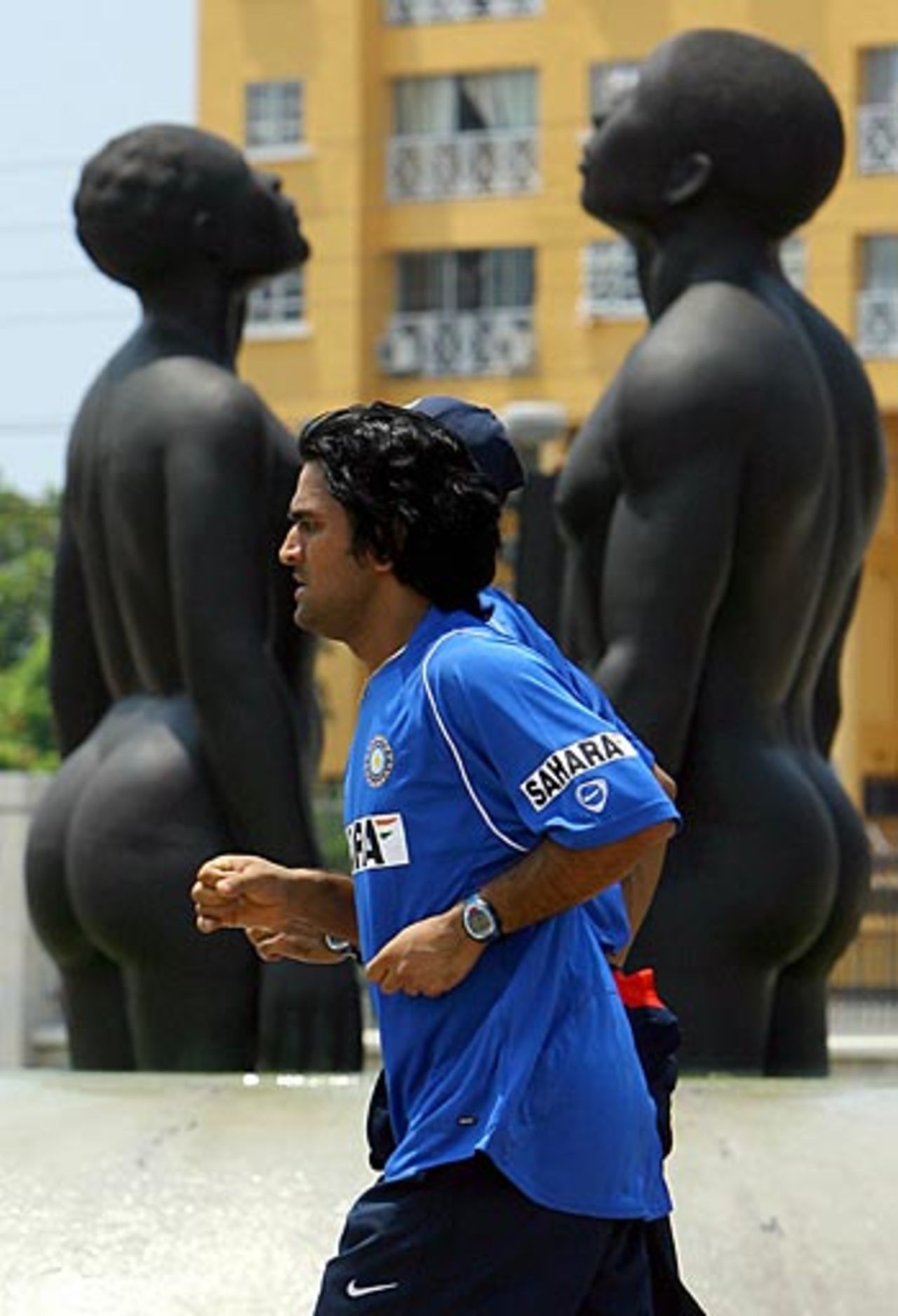 Mahendra Singh Dhoni jogs past statues at the start of India's tour of West Indies, Kingston, May 13, 2006
