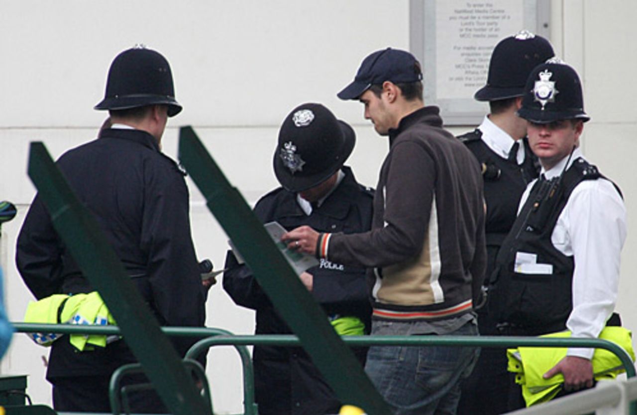 A spectator is held by the police after he ventured, briefly, onto the pitch to hand one of the fielders the ball, England v Sri Lanka, 1st Test, Lord's, May 14, 2006
