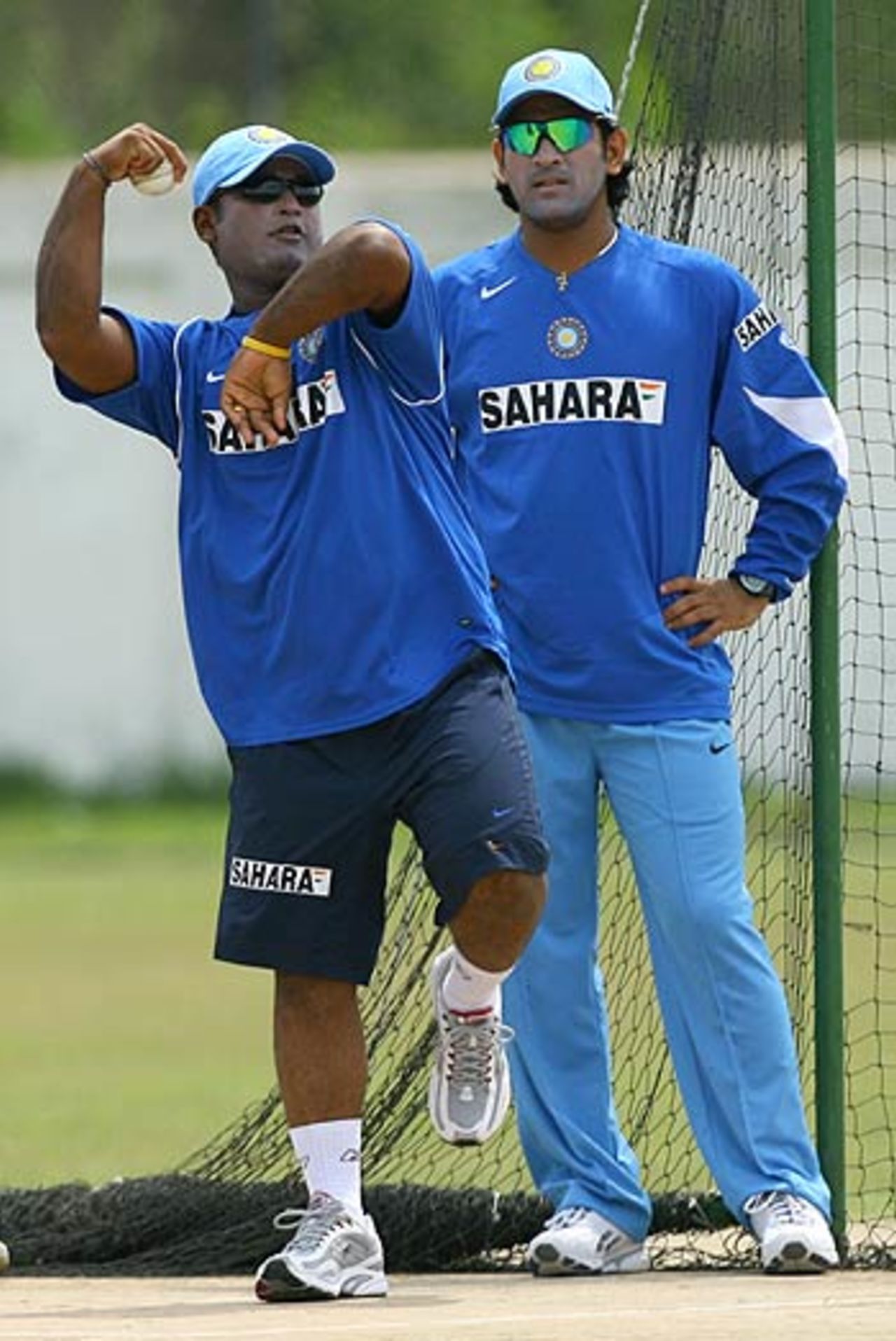 Ramesh Powar bowls as Mahendra Singh Dhoni looks on during the Indian team's practice session in Spanish Town, May 14, 2006