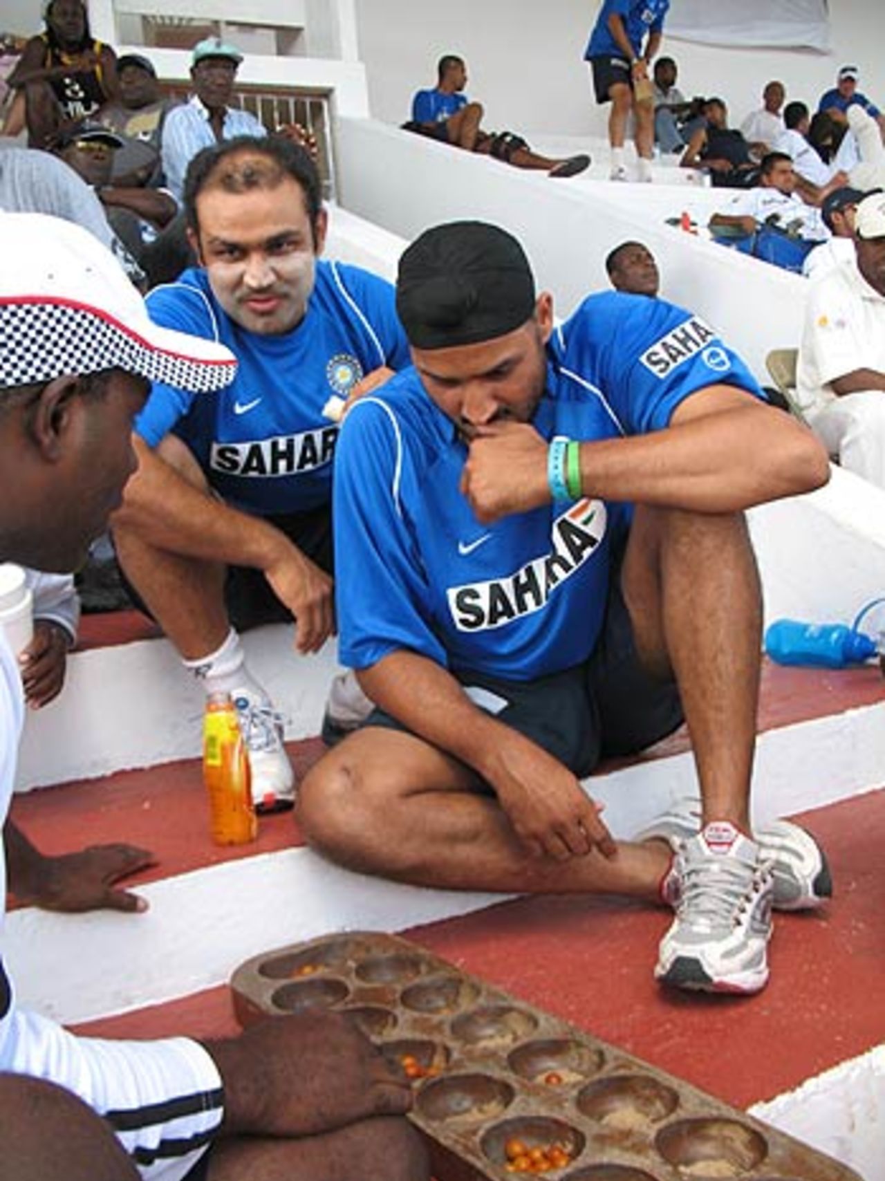 Harbhajan Singh is transfixed on a game of <i>Warri</i> as Virender Sehwag looks on, St Johns, Antigua, May 31 2006