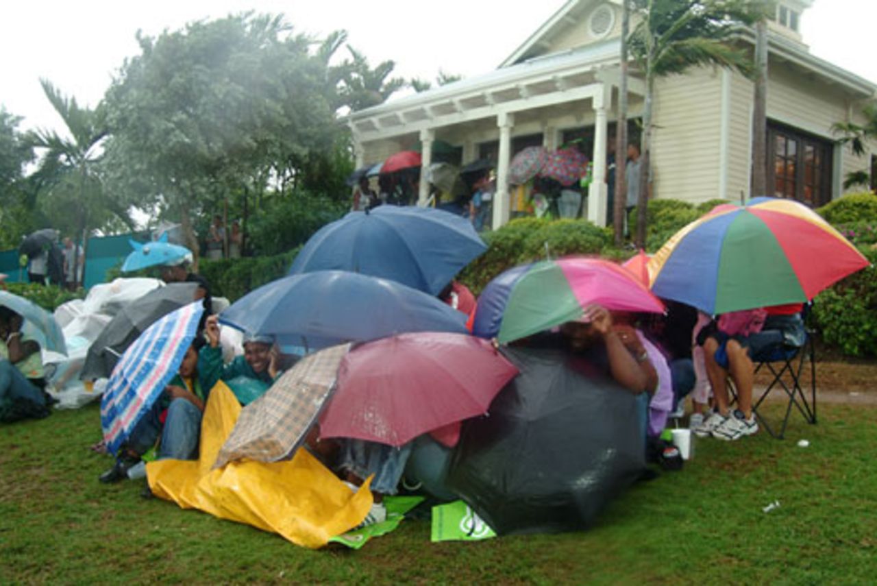 Spectators huddle for shelter as rain lashes down, Guyana v Jamaica, Stanford 20/20, July 28, 2006 	