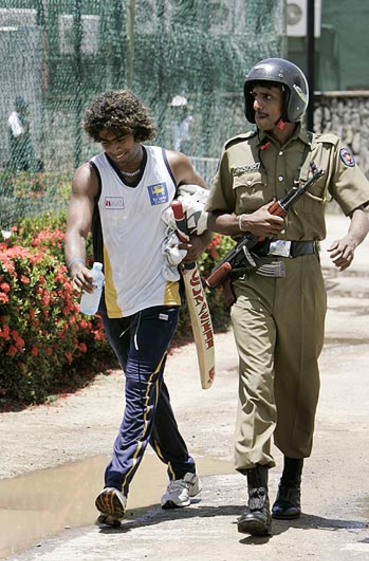 Lasith Malinga is escorted by a police official, Sinhalese Sports Club, Unitech Cup, Colombo, August 15, 2006