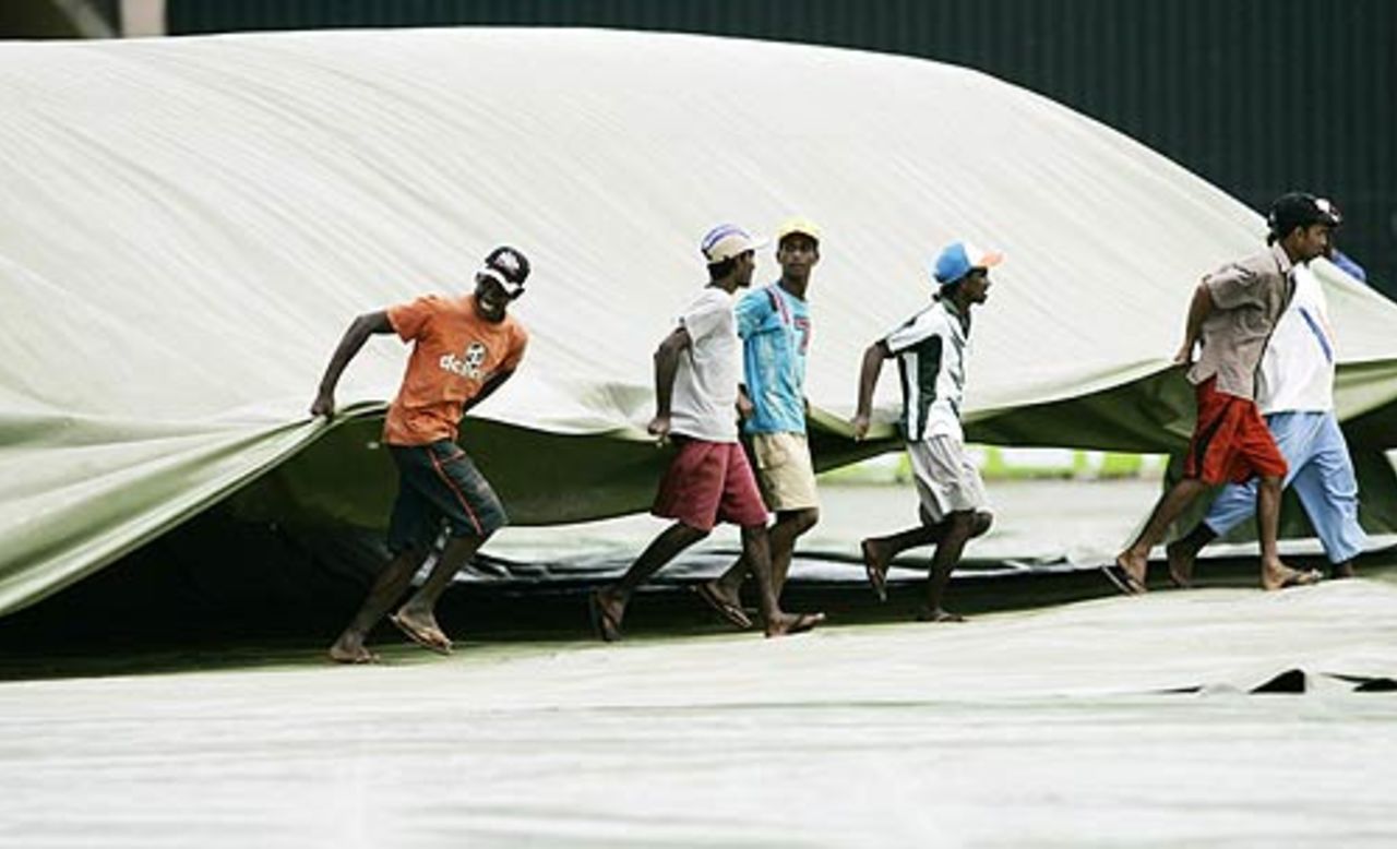 Groundstaff bring on the covers at the SSC, Colombo, August 18, 2006