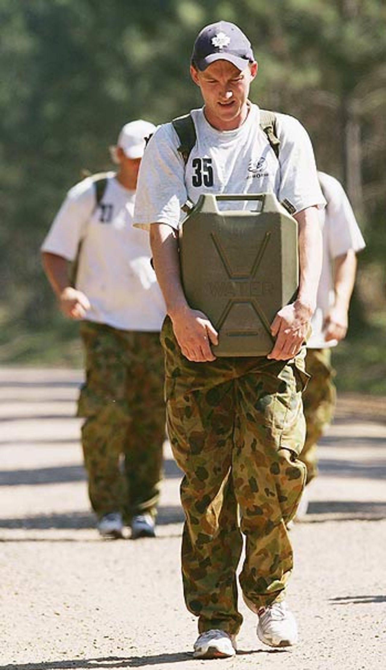 Brett Lee uses a different technique to carry the jerry can on his shoulder during an outback boot camp in the Beerwah State Forest, Brisbane, August 23, 2006