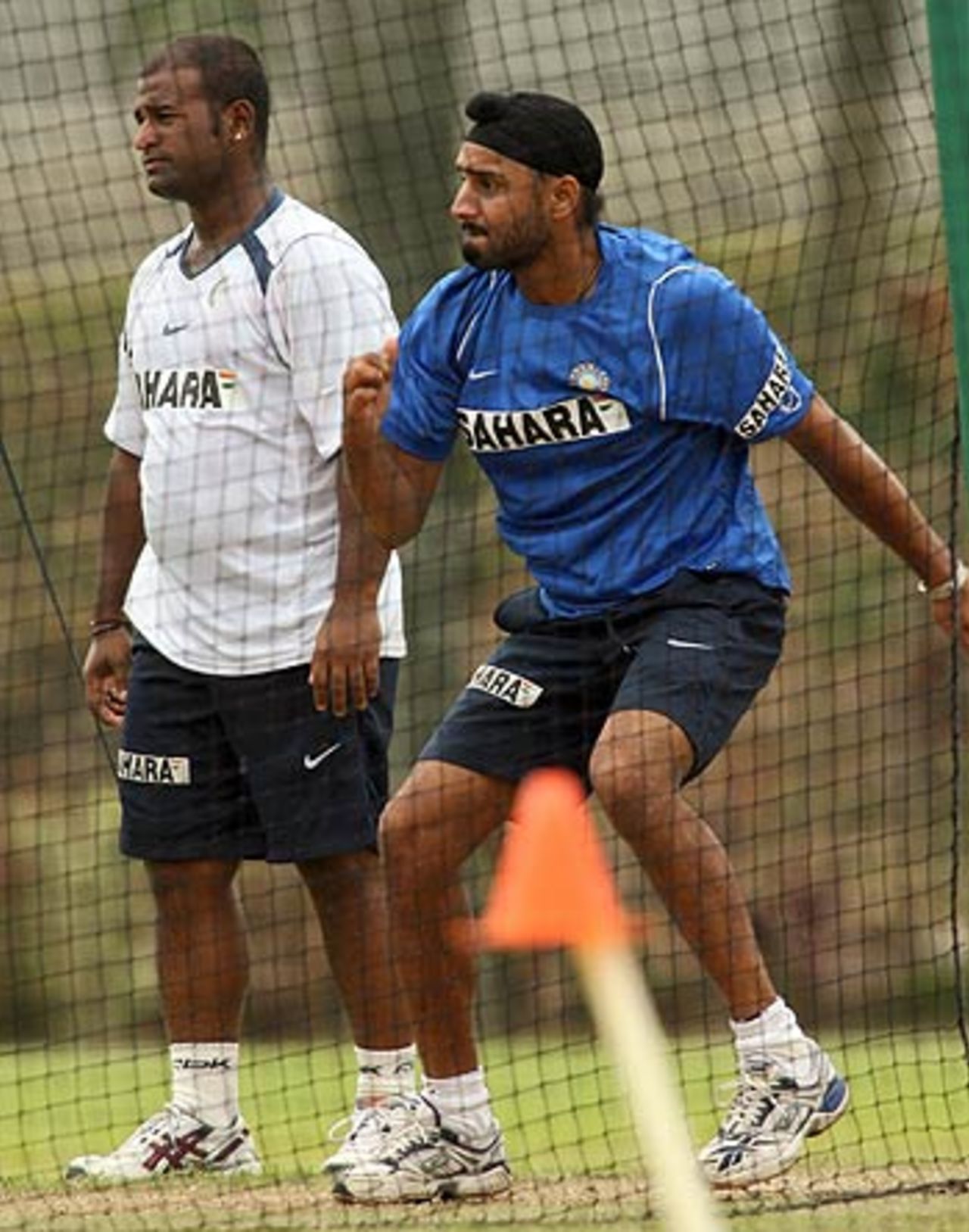 Harbhajan Singh enjoys a bowling session while Romesh Powar looks on, at the Kinrara Academy Oval, Kuala Lumpur, September 19, 2006