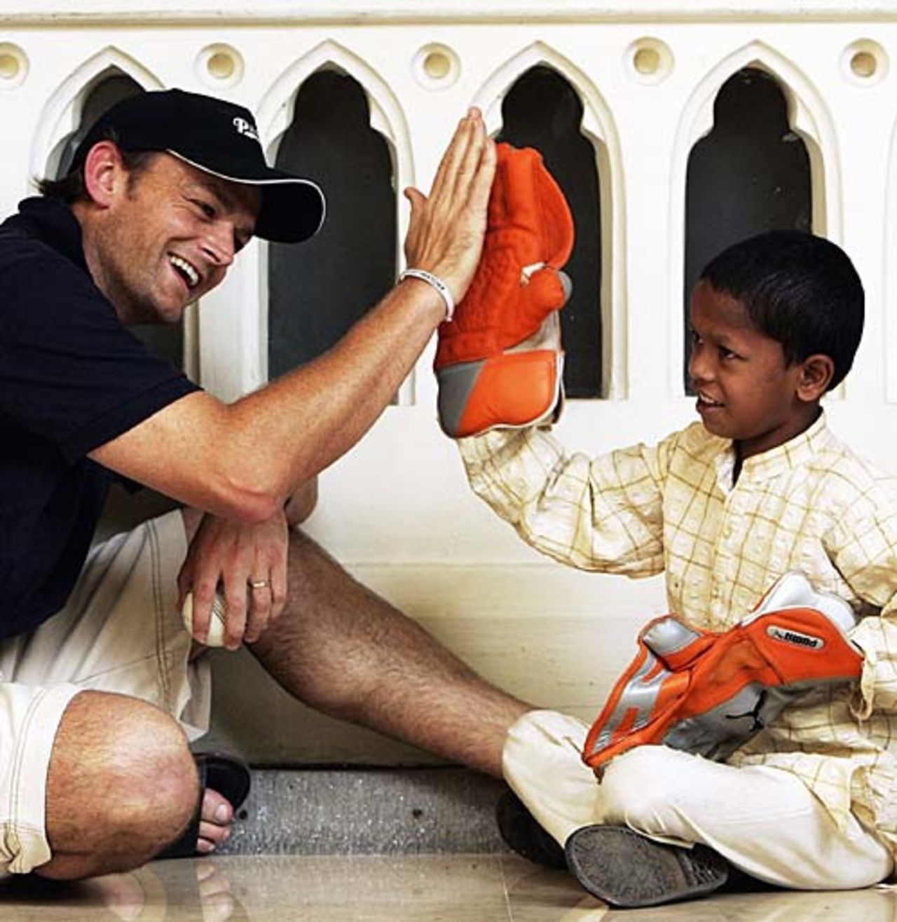 Adam Gilchrist has competition for the gloves giving five to Mangesh, the child he sponsors, Taj Mahal hotel, October 17, 2006