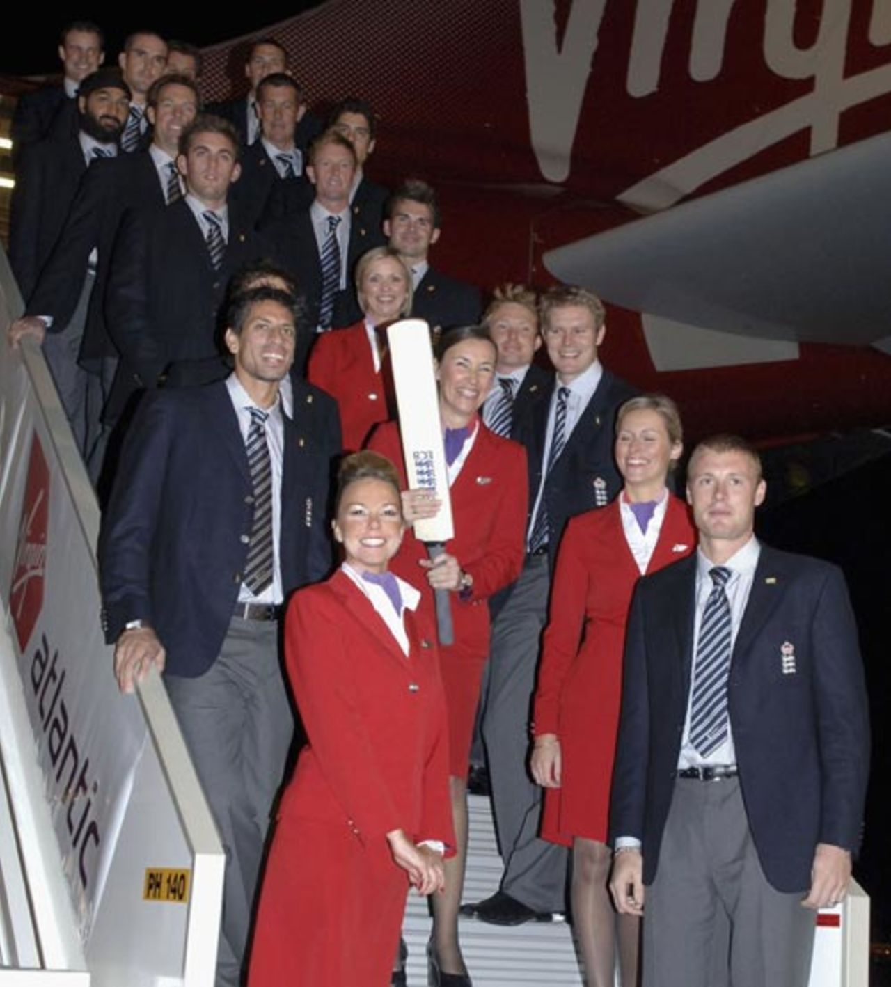 The England squad pose as they board a plane to start their defence of the Ashes