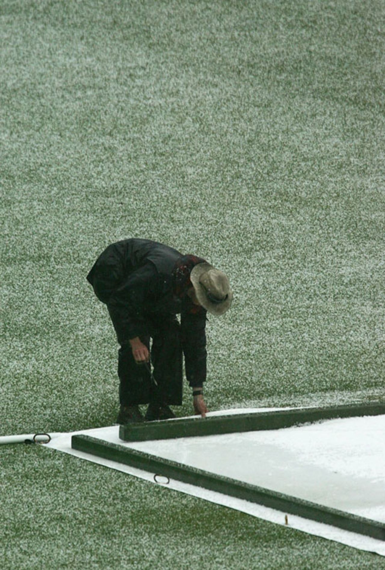 A groundsman covers the pitch during a hail storm, Victoria v Tasmania, MCG, November 15, 2006