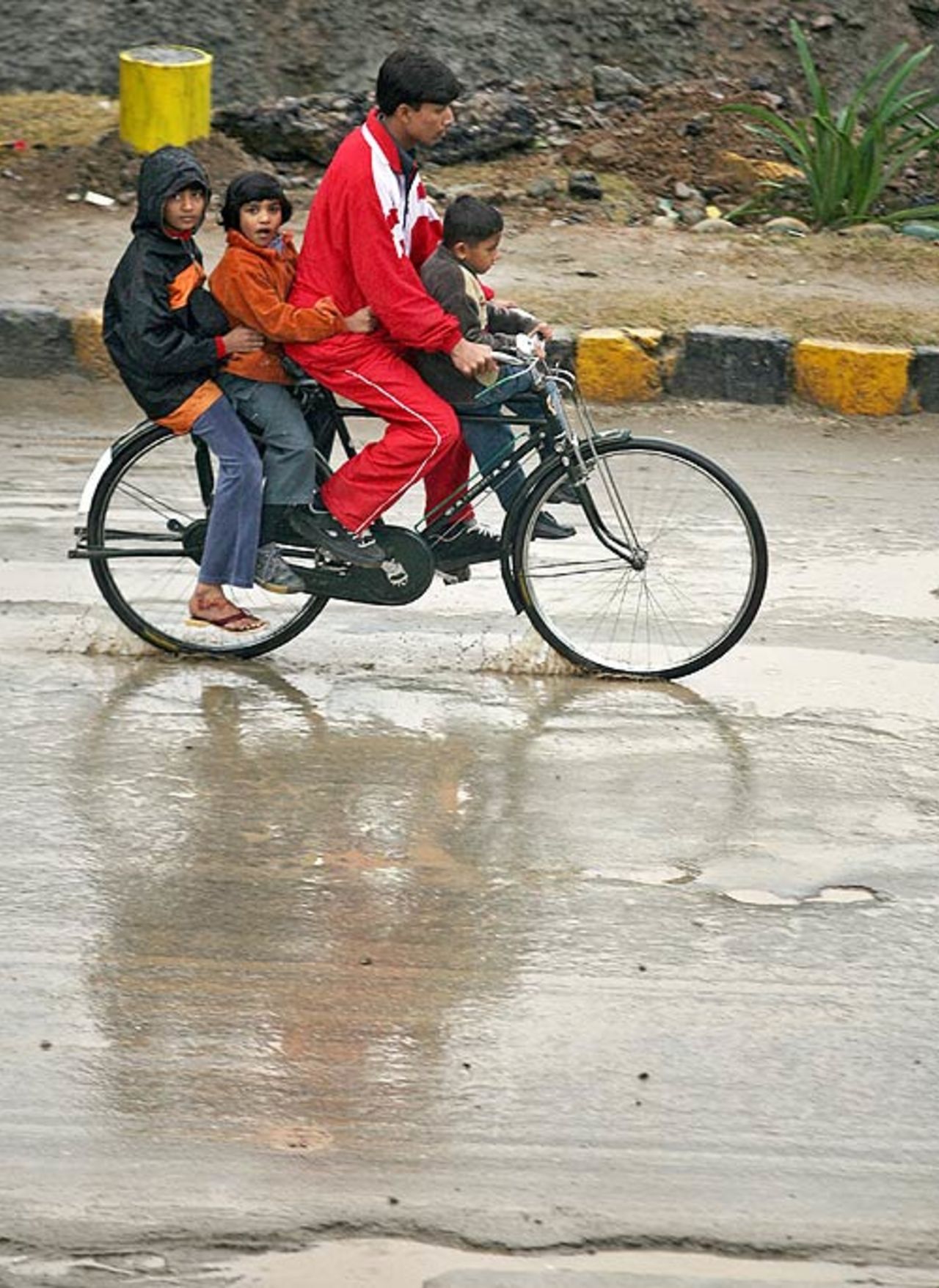 A man transports children across the rain-drenched roads, Rawalpindi, December 3, 2006