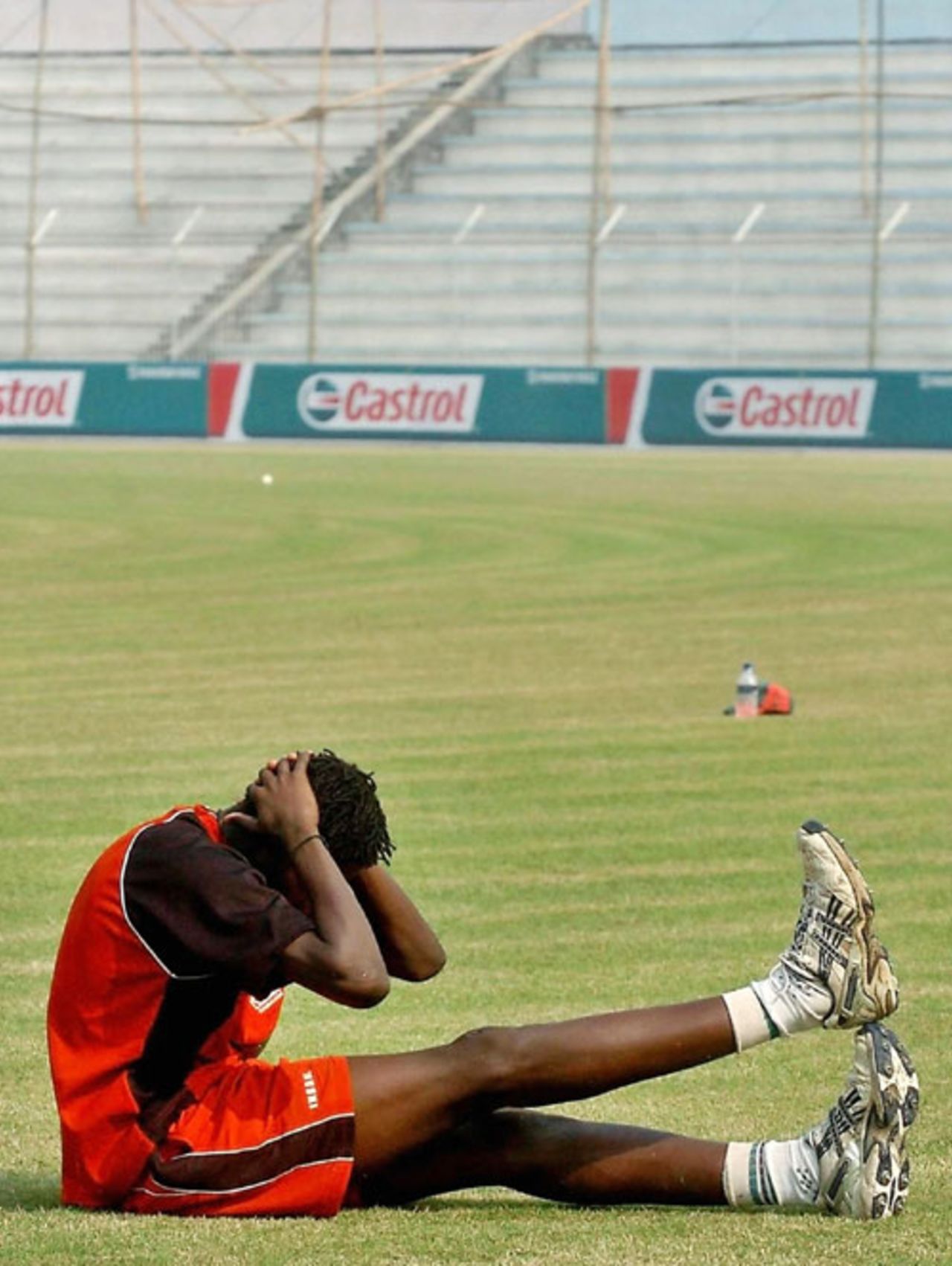 Christopher Mpofu stretches in the centre of an empty stadium, Bangladesh v Zimbabwe, Bogra, December 4, 2006
