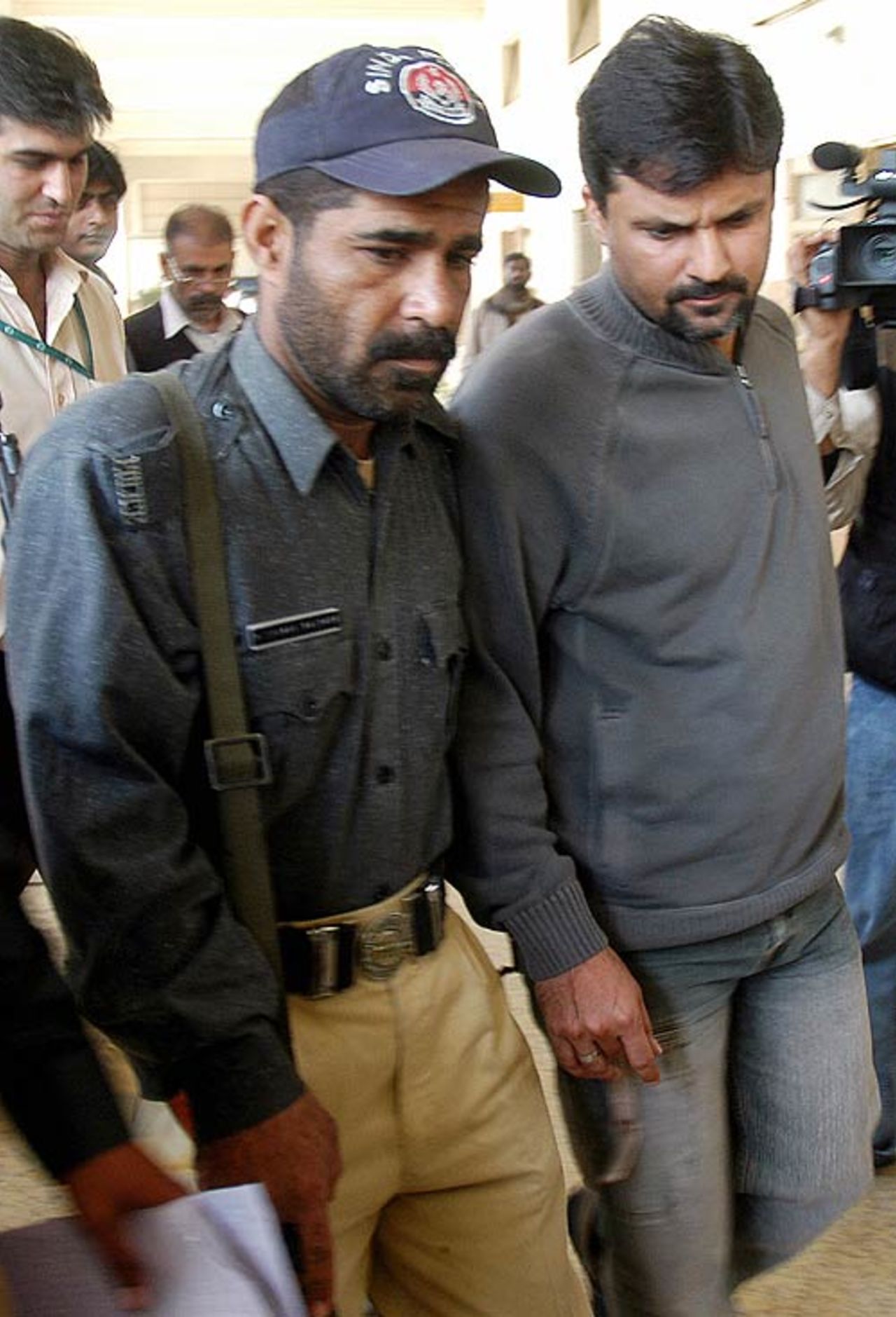 Moin Khan makes his way to the court, escorted by a policeman, Karachi, January 16, 2007