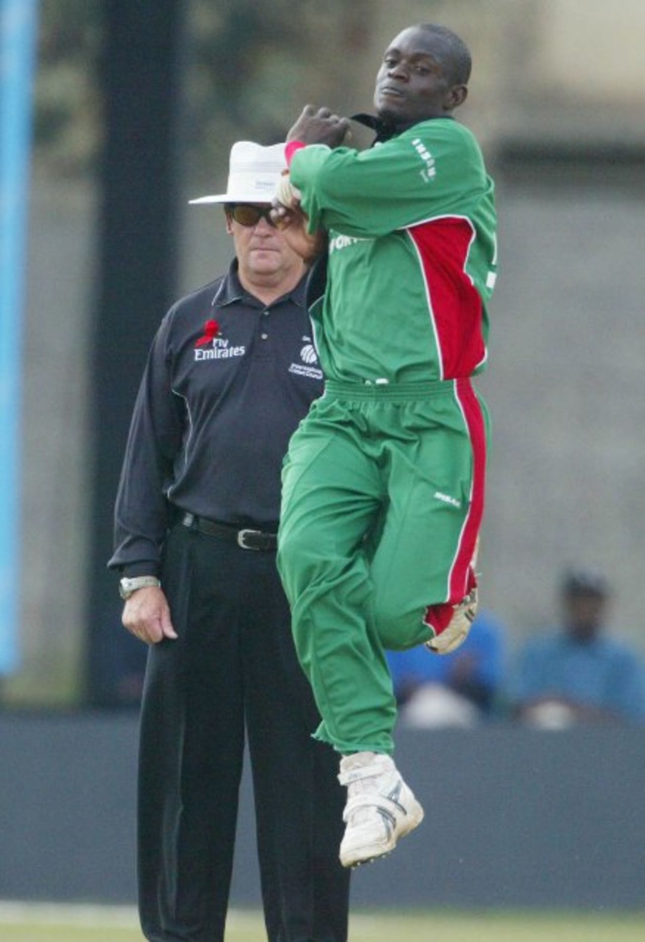 Kenya's bowler, Lameck Onyango, in action as the New Zealand umpire, Gary Baxter, watches during the Final of ICC World Cricket League Division 1 against Scotland at the Nairobi Gymkhana Sports Club in Nairobi, Wednesday, Feb. 7