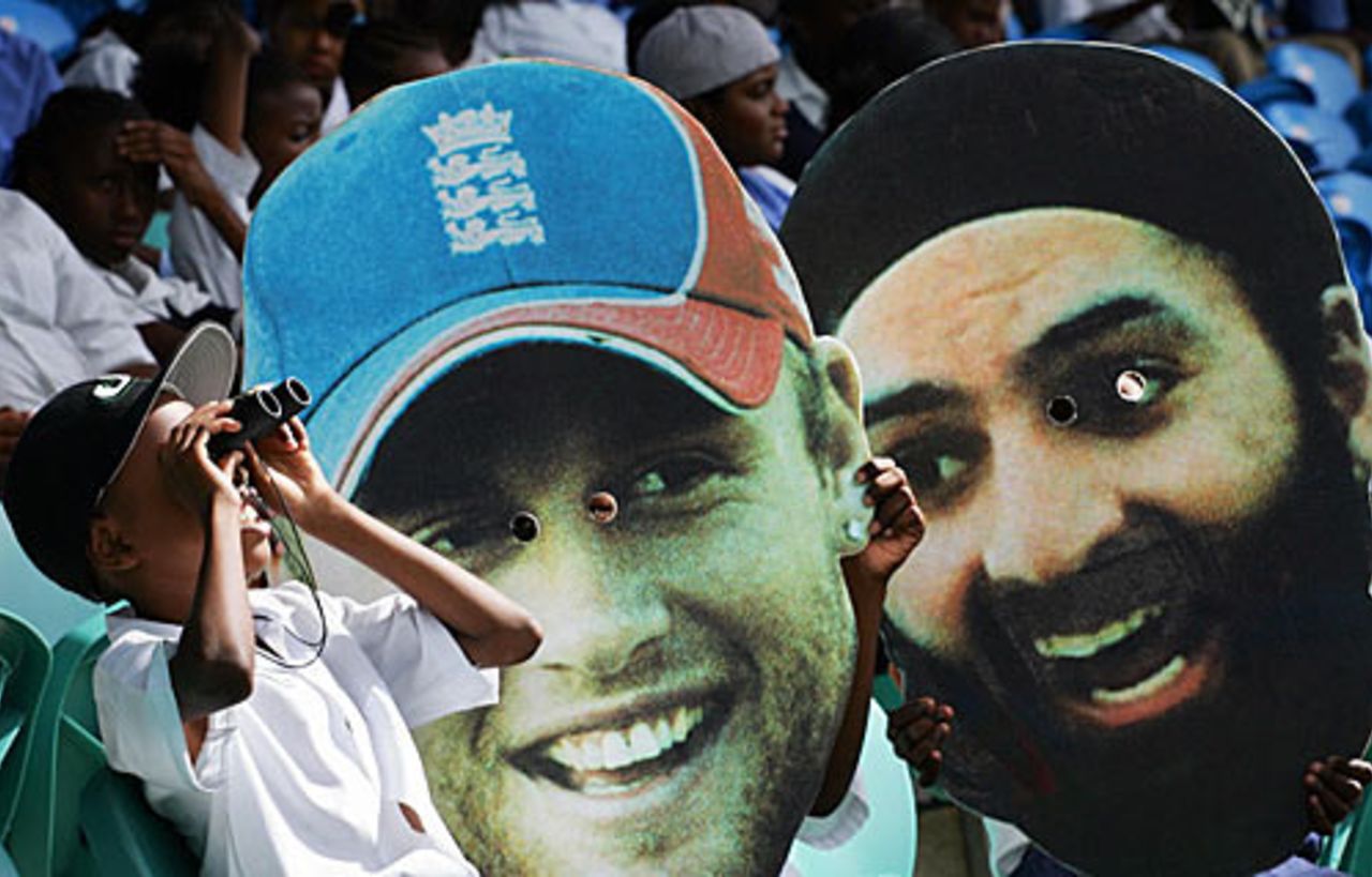 A young fan looks through binoculars in front of two large masks of Andrew Flintoff and Monty Panesar, Arnos Vale, March 5, 2007