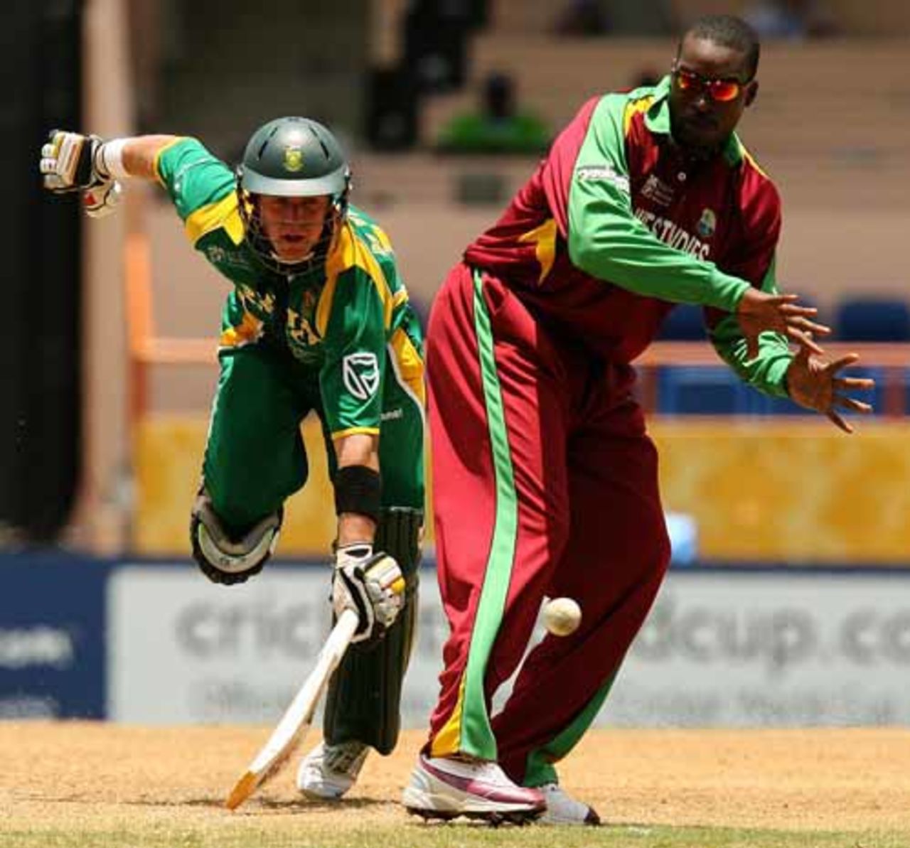 AB de Villiers stretches to make his ground as a throw comes in to West Indies bowler Chris Gayle