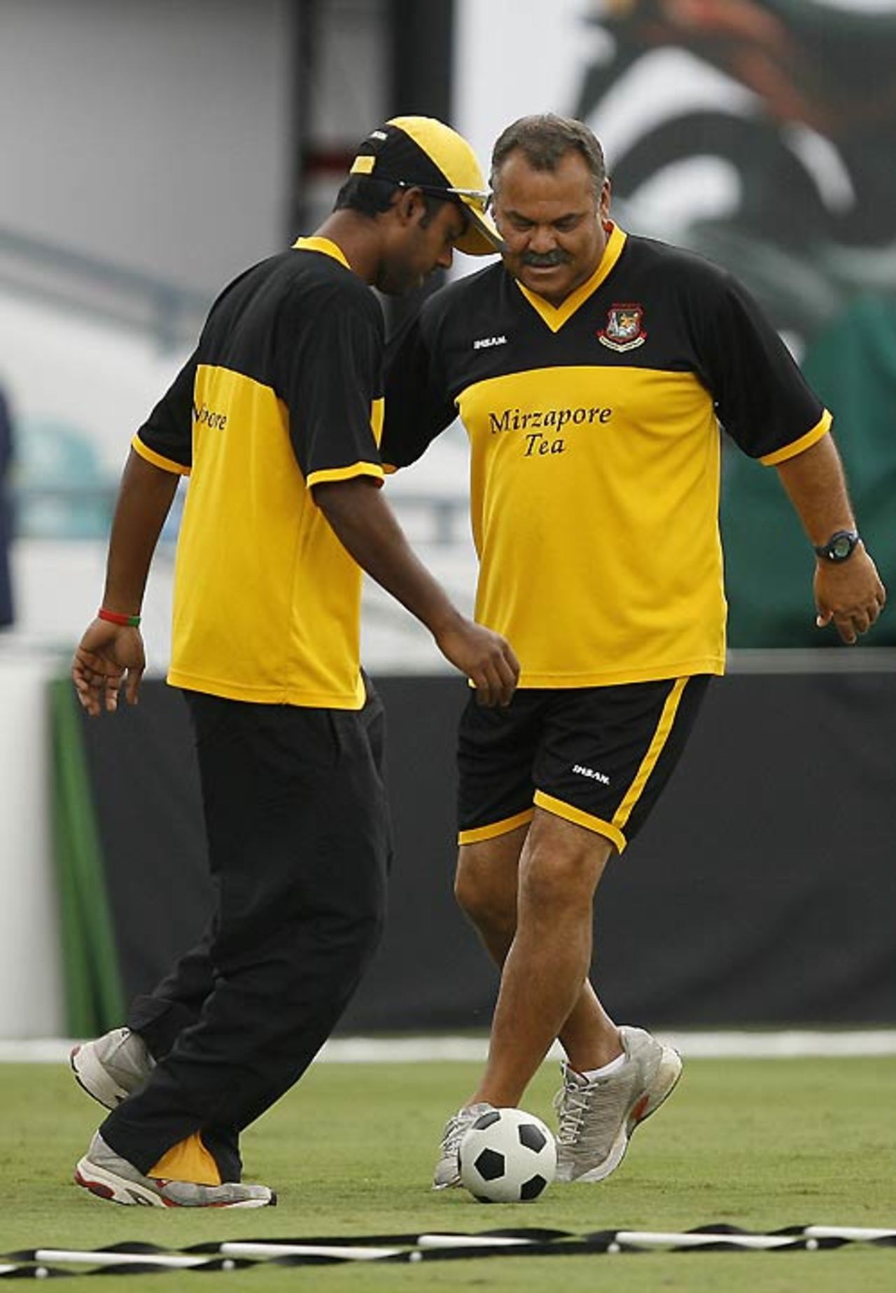 Dav Whatmore and Syed Rasel play soccer during a training session at the Kensington Oval, Barbados, April 14, 2007 