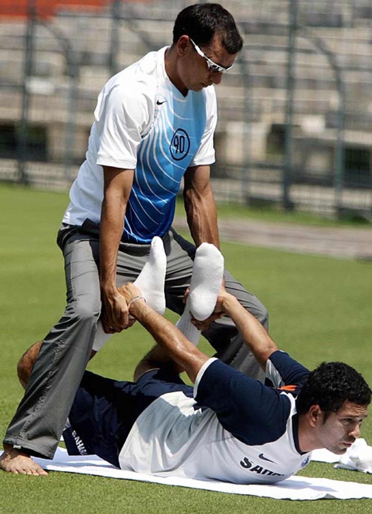 Sachin Tendulkar performs yoga exercises with the assitance of yoga expert Sukhdev Kumar at the training camp, Kolkata, May 6, 2007