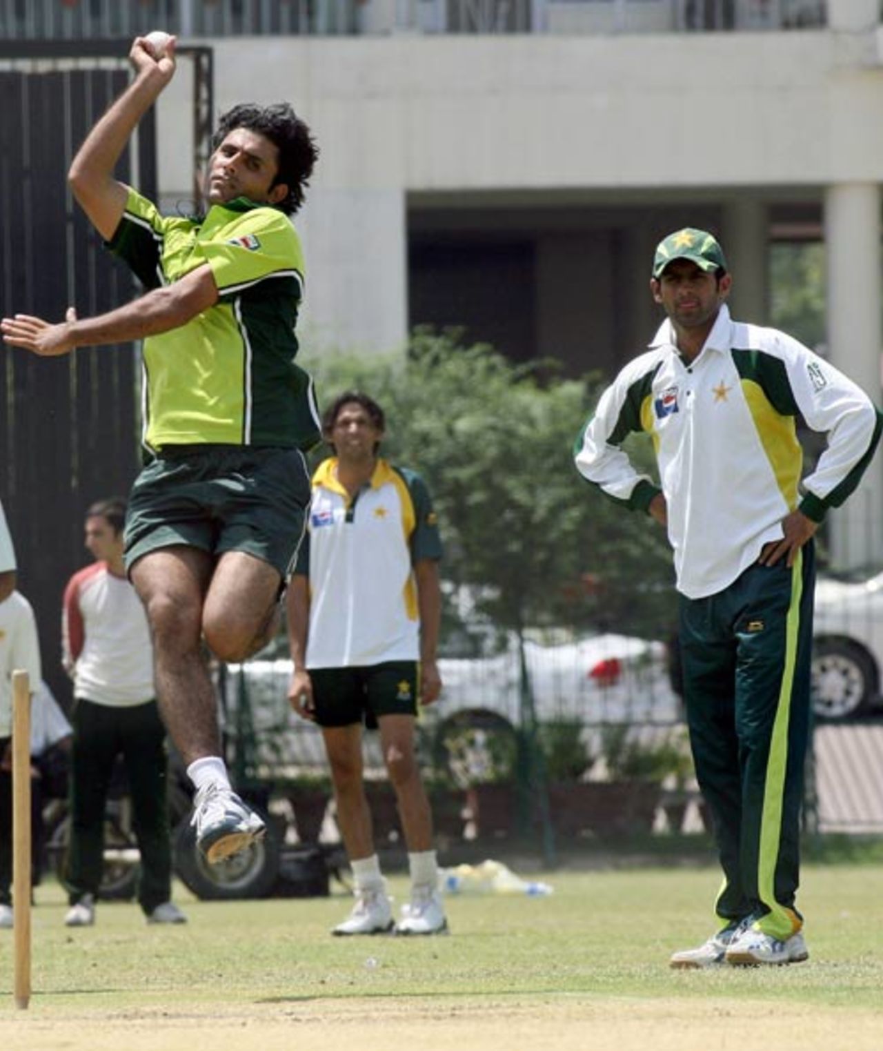 Abdul Razzaq about to deliver a ball as captain Shoaib Malik watches during practice at the Gaddafi Stadium in Lahore, May 12, 2007