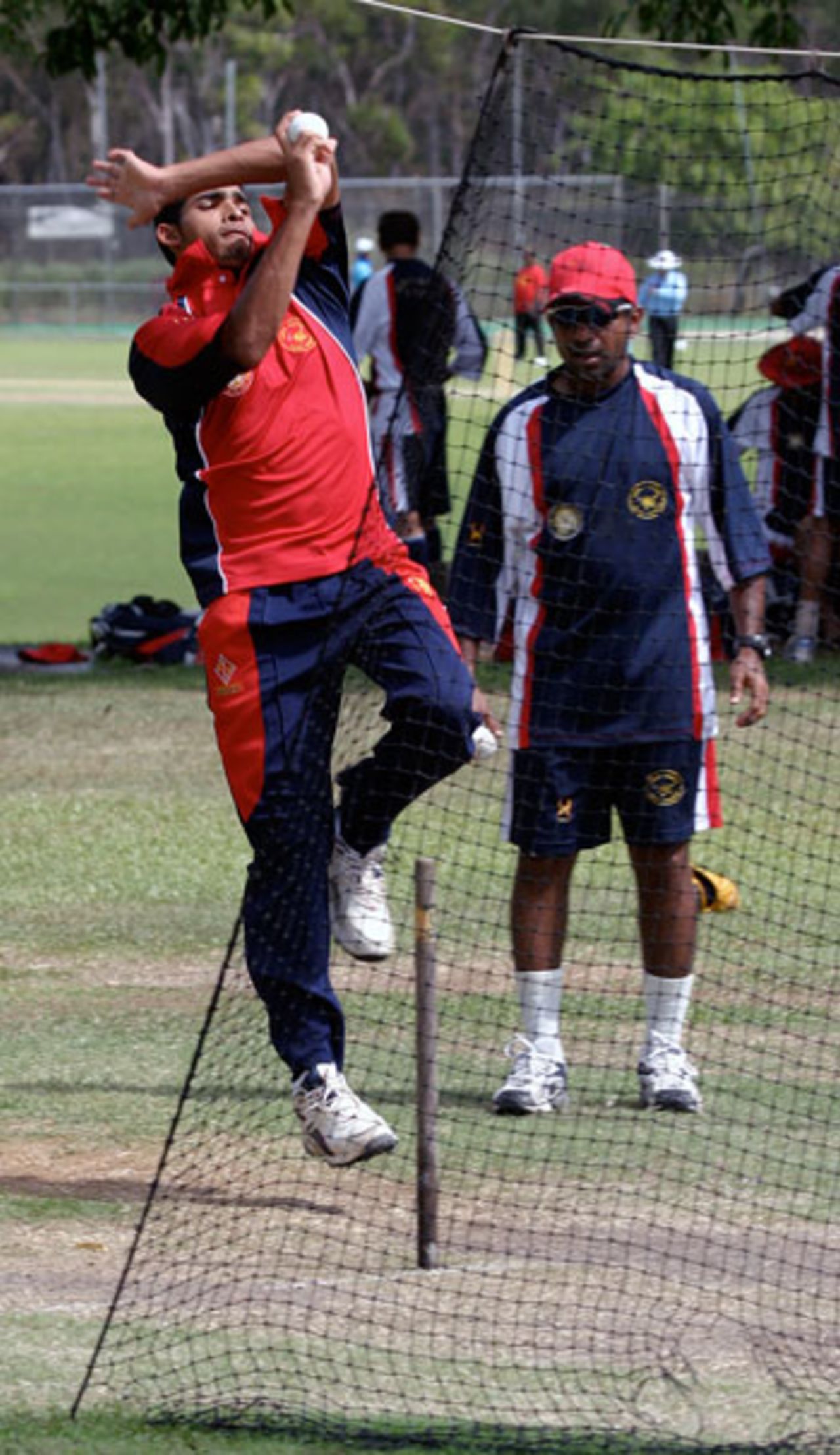 Irfan Ahmed bowls under the watchful eye of coach Sameer Dighe at the Marrara Sports Complex, Darwin
