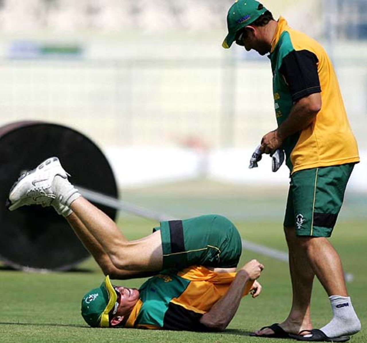 Shaun Pollock stretches as team-mate Mark Boucher chats with him during a practice session at the Chinnaswamy Stadium, Bangalore, June 5, 2007