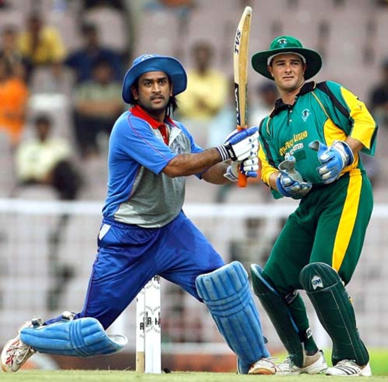 Mahendra Singh Dhoni plays a full blooded pull shot as  Mark Boucher looks on  during the third ODI of the Afro-Asia Cup, Chennai, June 10, 2007
