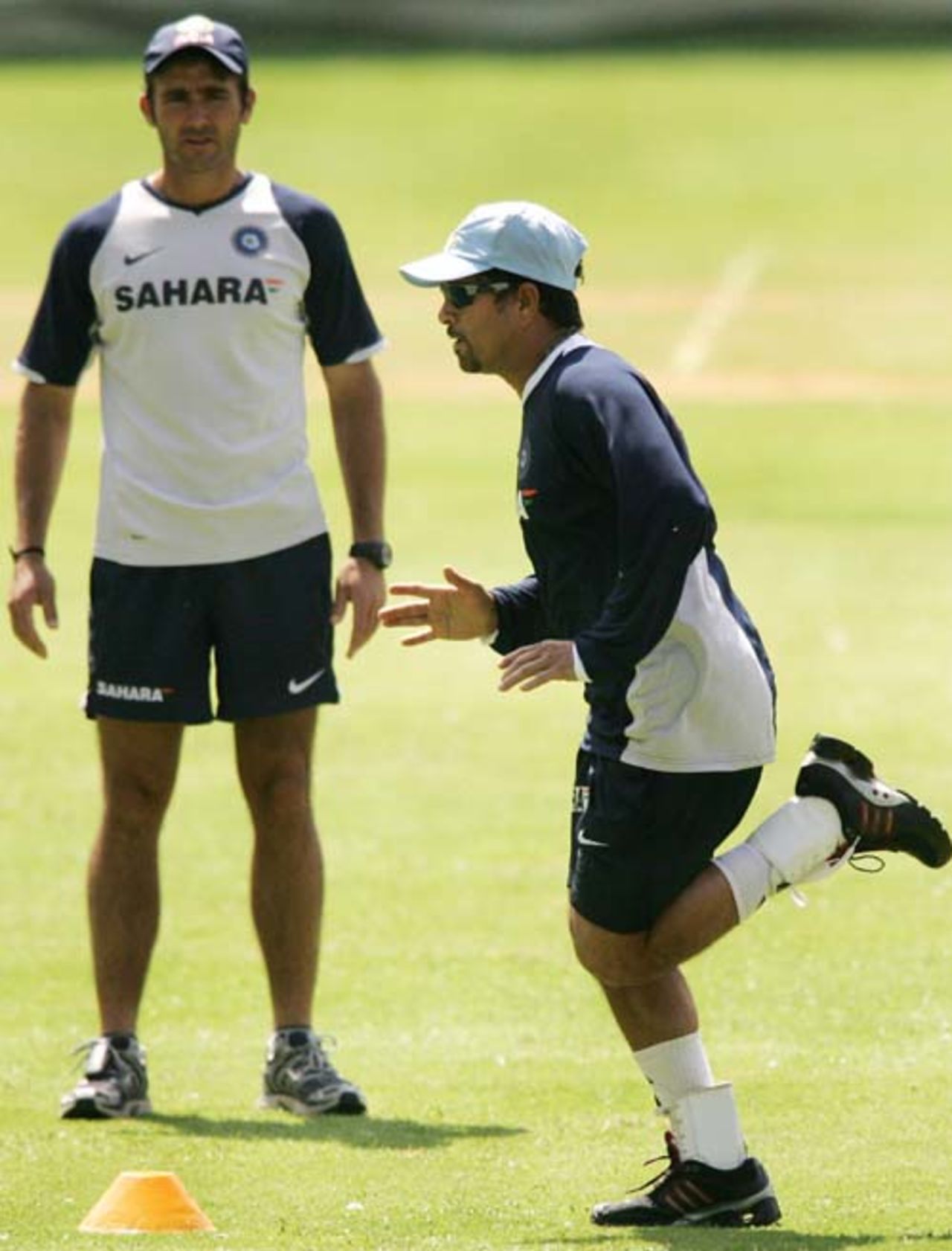 Sachin Tendulkar runs as trainer Gregory King keeps observes him during the final day of the batsman's camp at the Chinnaswami Stadium, Bangalore, June 12, 2007