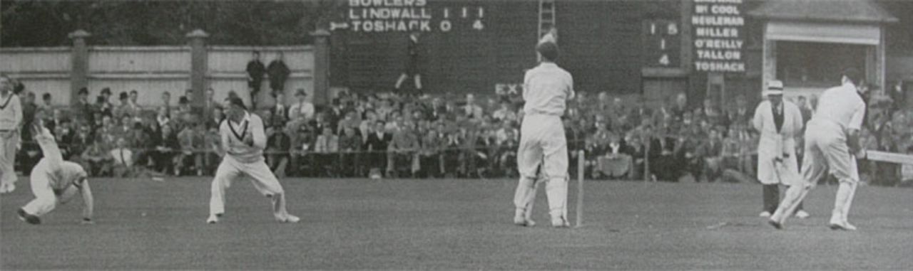 Keith Miller displays great agility to catch Walter Hadlee at leg slip, watched by Sid Barnes, Ian Johnson and wicketkeeper Don Tallon. Note the list of the fielding side on the scoreboard. A bulb would light up when the player fielded the ball, New Zealand v Australia, Wellington, March 29, 1946