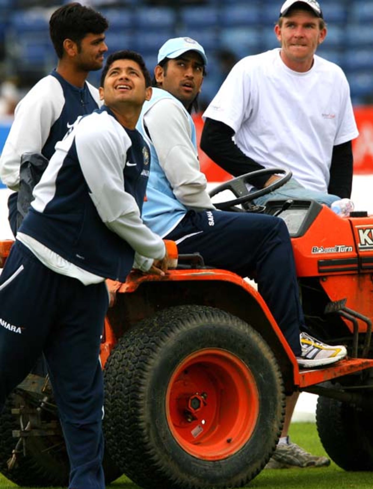 Mahendra Singh Dhoni gets behind a tractor in the company of Piyush Chawla and RP Singh, India v South Africa, 3rd ODI, Belfast, July 1, 2007