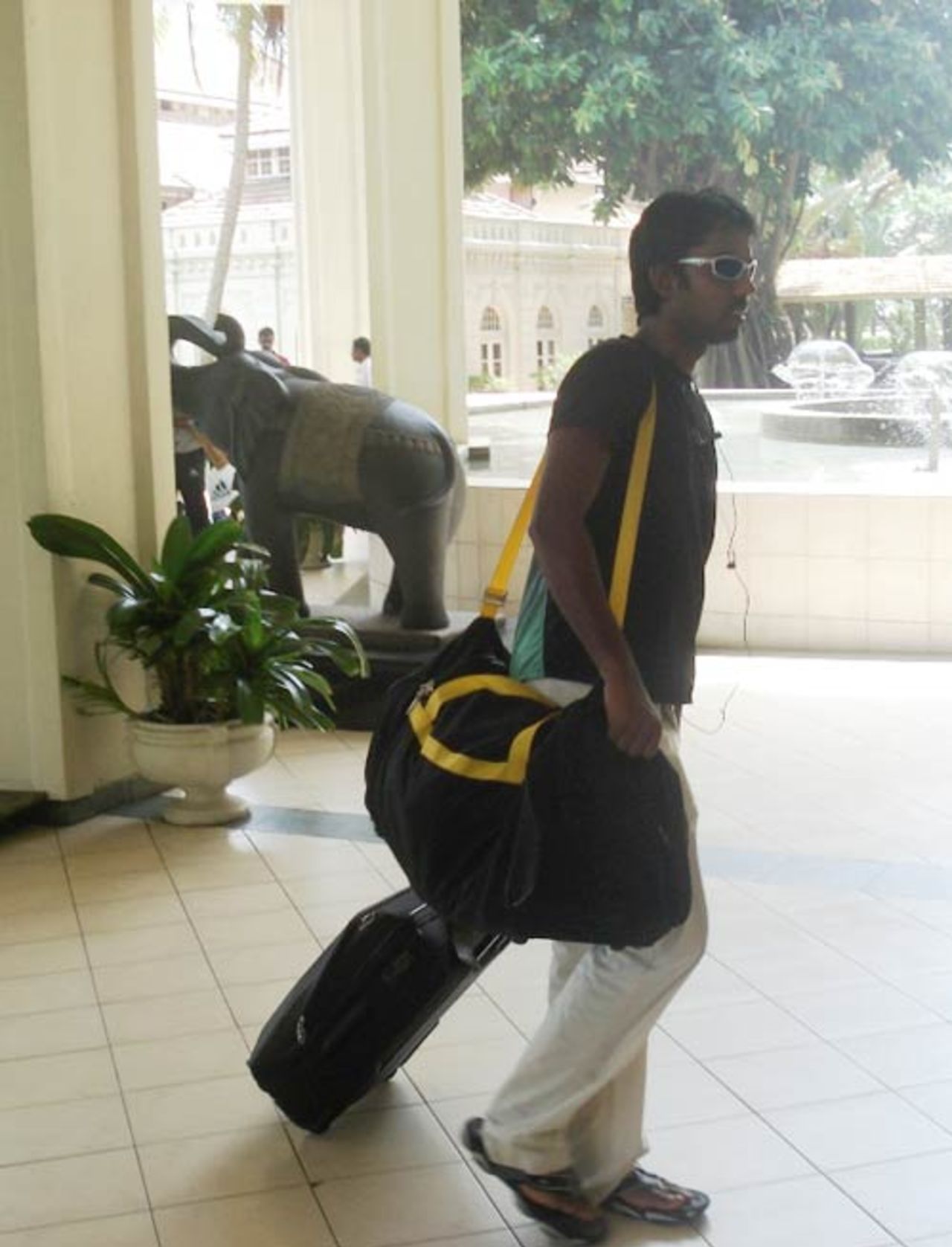 Syed Rasel carries his bags into the team hotel in Colombo, July 15, 2007