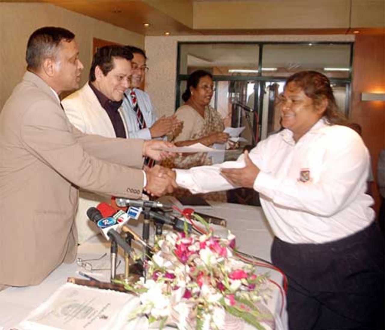 The BCB president, Major General Sina Ibn Jamali, hands over a cheque to Tajkia Akhter, the captain of the victorious Bangladesh women's team who won the ACC women's tournament