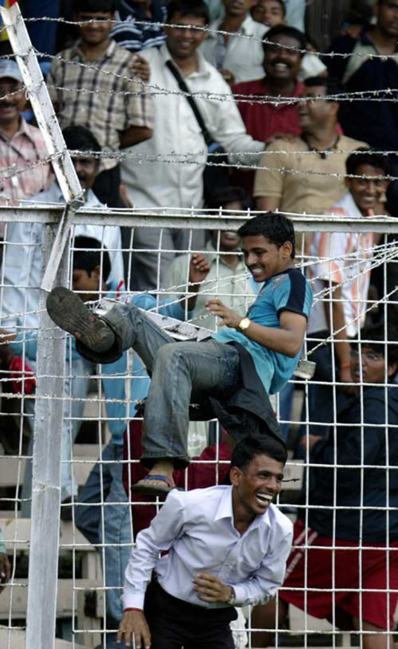 An Indian fan jumps across the barbed wire fence to get a closer look at the national team at a welcome ceremony, Wankhede Stadium, Mumbai, September 26, 2007