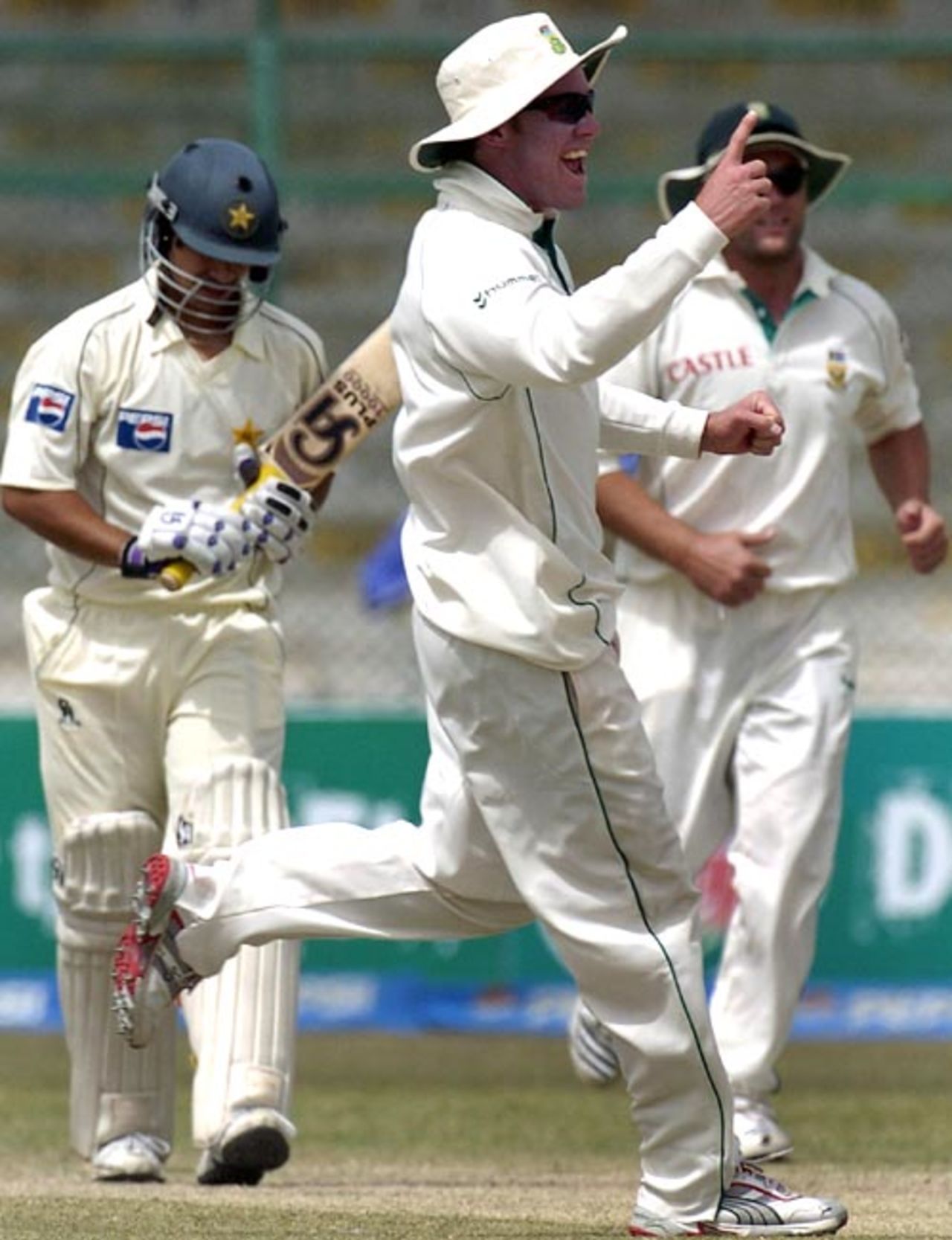 Salman Butt walks back to the pavilion while AB de Villiers celebrates, Pakistan v South Africa, 1st Test, Karachi, 3rd day, October 3, 2007