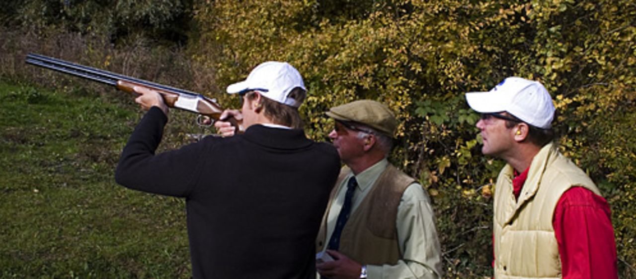 Chris Broad watches his son, Stuart, take aim during a clay pigeon shoot, West London Shooting School, November 1, 2007