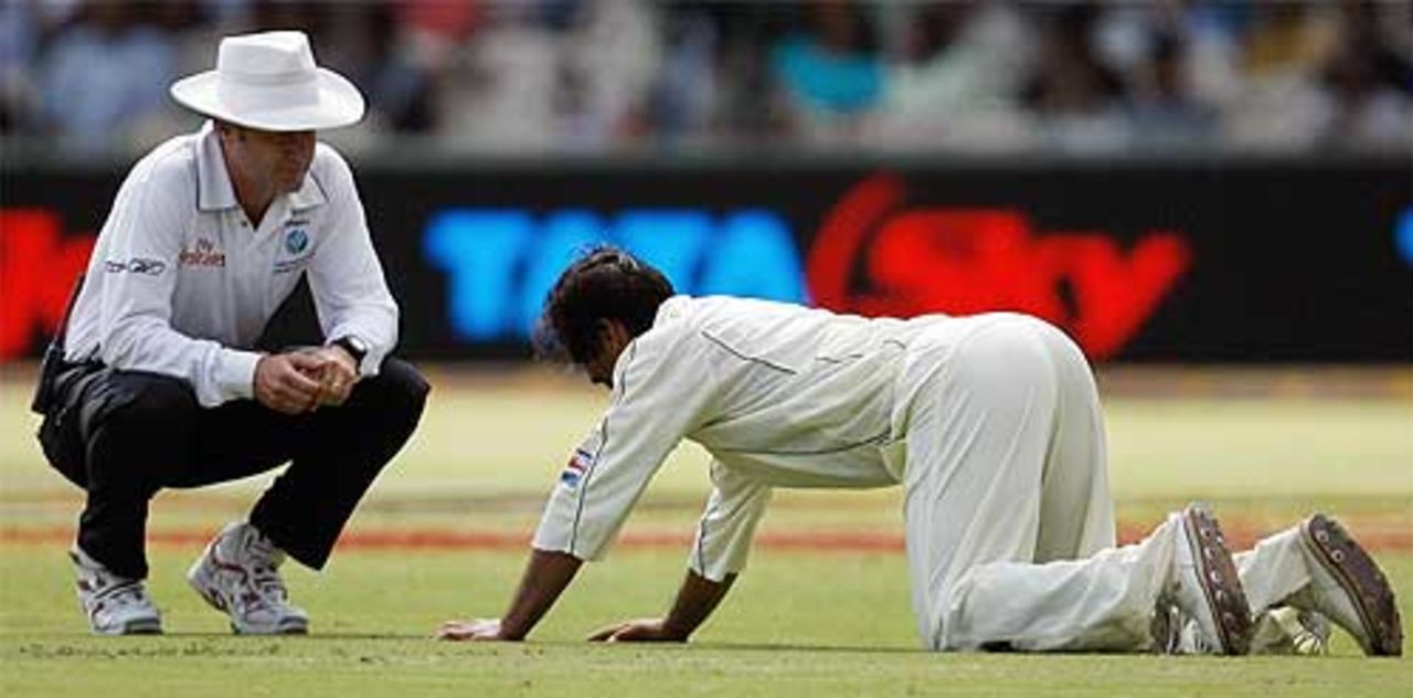 Shoaib Akhtar on all fours struggling with cramps as umpire Simon Taufel watches on, India v Pakistan, 3rd Test, Bangalore, 1st day, December 8, 2007