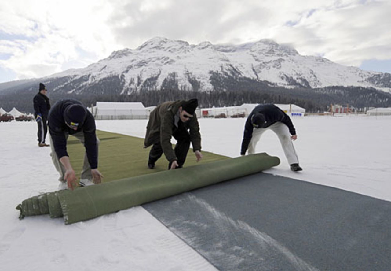Players roll out a cricket pitch carpet to play on the ice, St Moritz, Switzerland, January 31, 2008