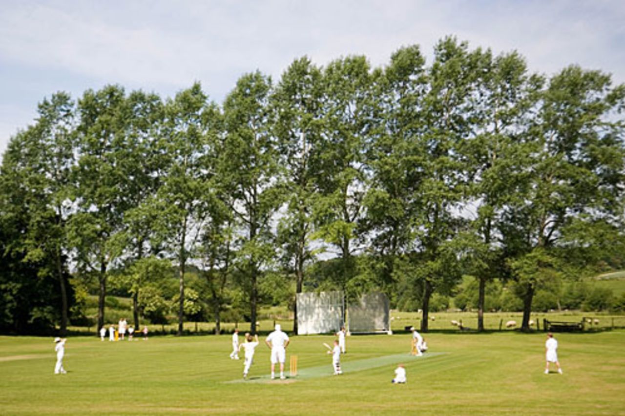 Children play cricket on village pitch, Swinbrook, The Cotswolds, June 3, 2007