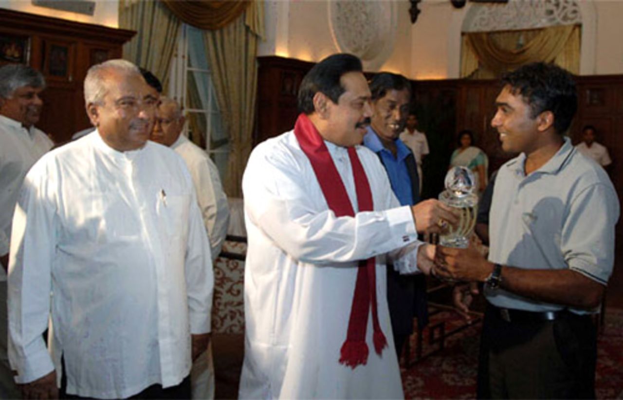 Mahela Jayawardene presents the Asia Cup trophy to Mahinda Rajapakse, the Sri Lankan president as sports minister Gamini Lokuge looks on, Colombo, July 9, 2008