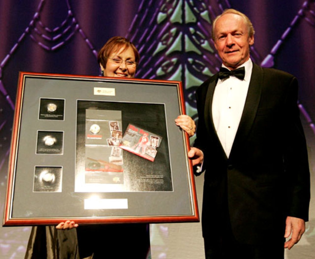 Janine Murphy of the Royal Australian Mint presents John Bradman with a montage of a commemorative coin, Sydney, August 27, 2008