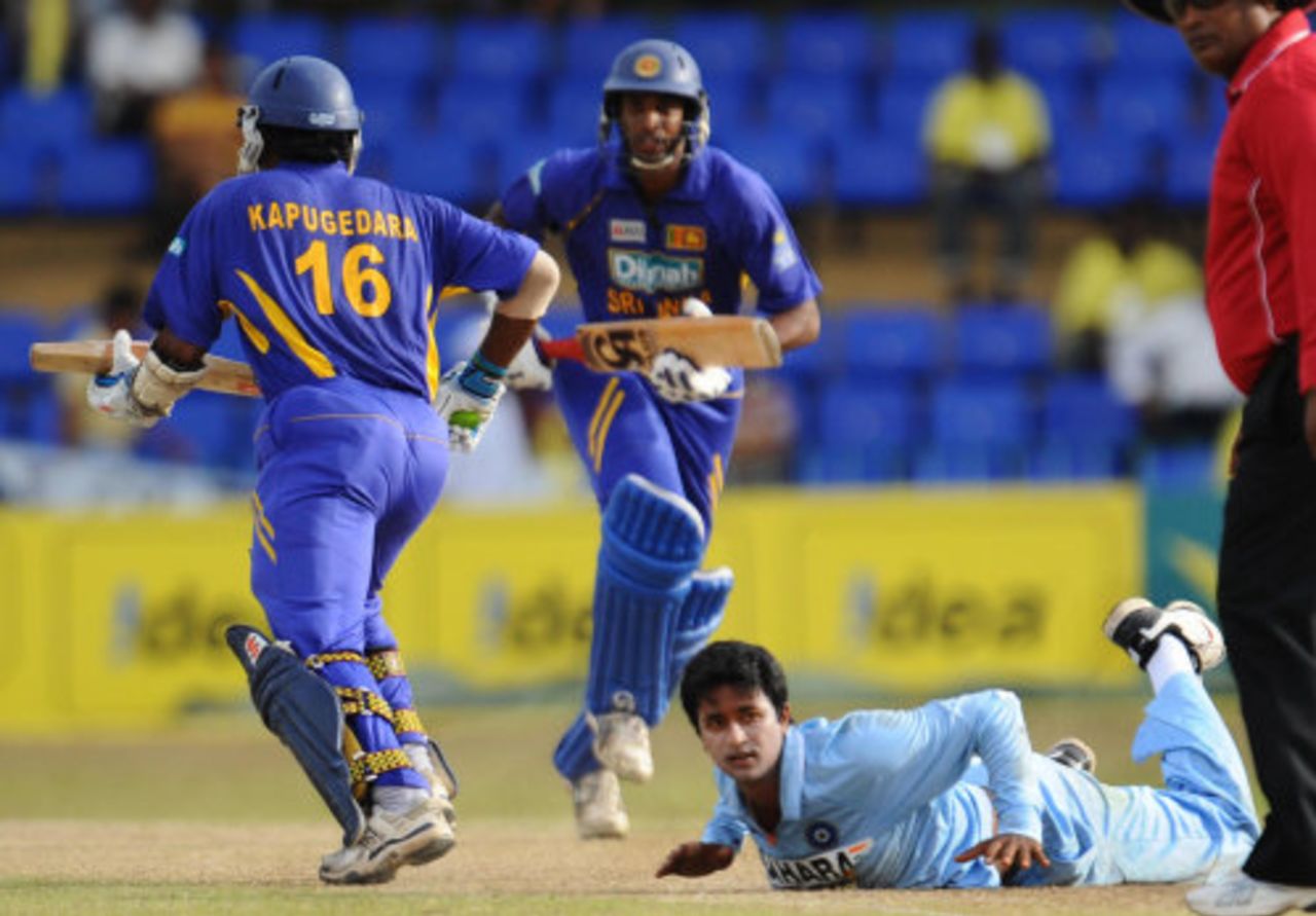Pragyan Ojha lies sprawled on the ground while Chamara Kapugedera and Jehan Mubarak take a run, Sri Lanka v India, 5th ODI, Colombo, August 29, 2008 
