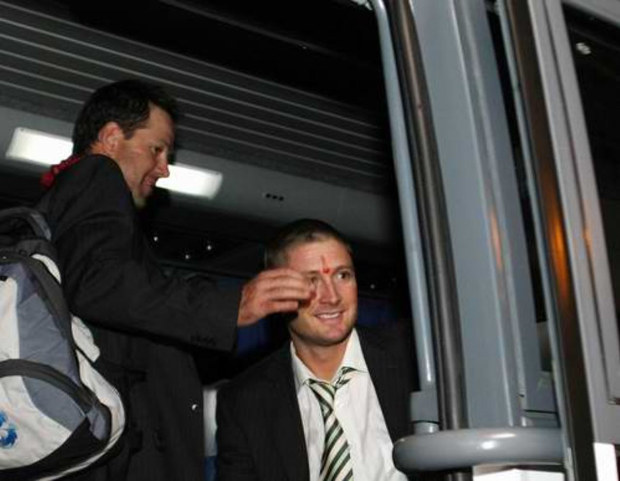Ricky Ponting and Michael Clarke board the team bus at the airport in Jaipur