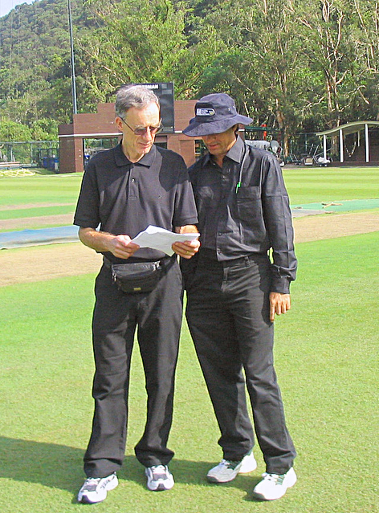 Umpires Roger Nissim and Tauseef Bukhari compare notes before the start of the game. HK Women v. JP Women at HKCC, 09.10.2008