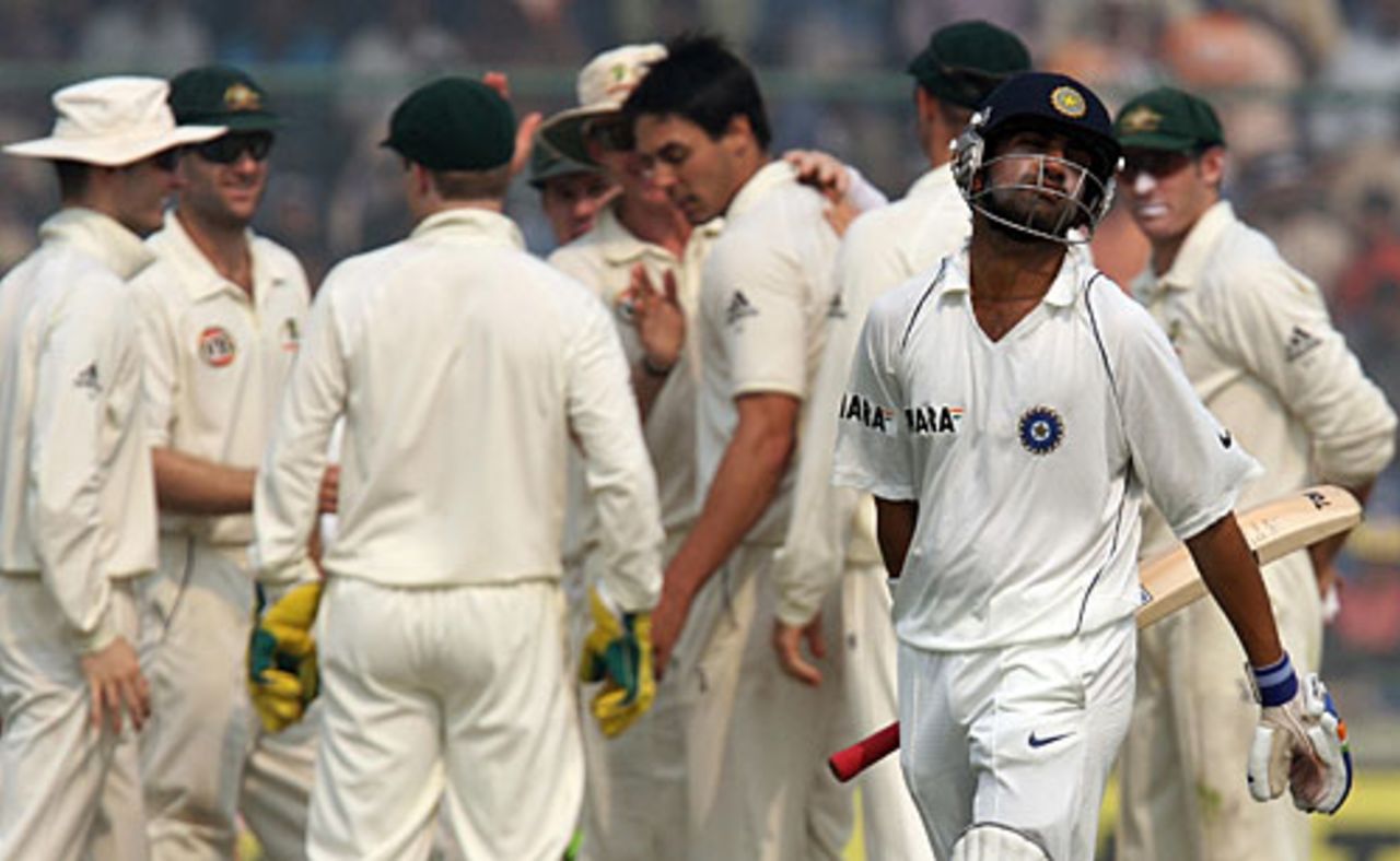 Gautam Gambhir walks back dejectedly after falling to Mitchell Johnson, who celebrates with his team-mates in the background, India v Australia, 3rd Test, Delhi, 5th day, November 2, 2008