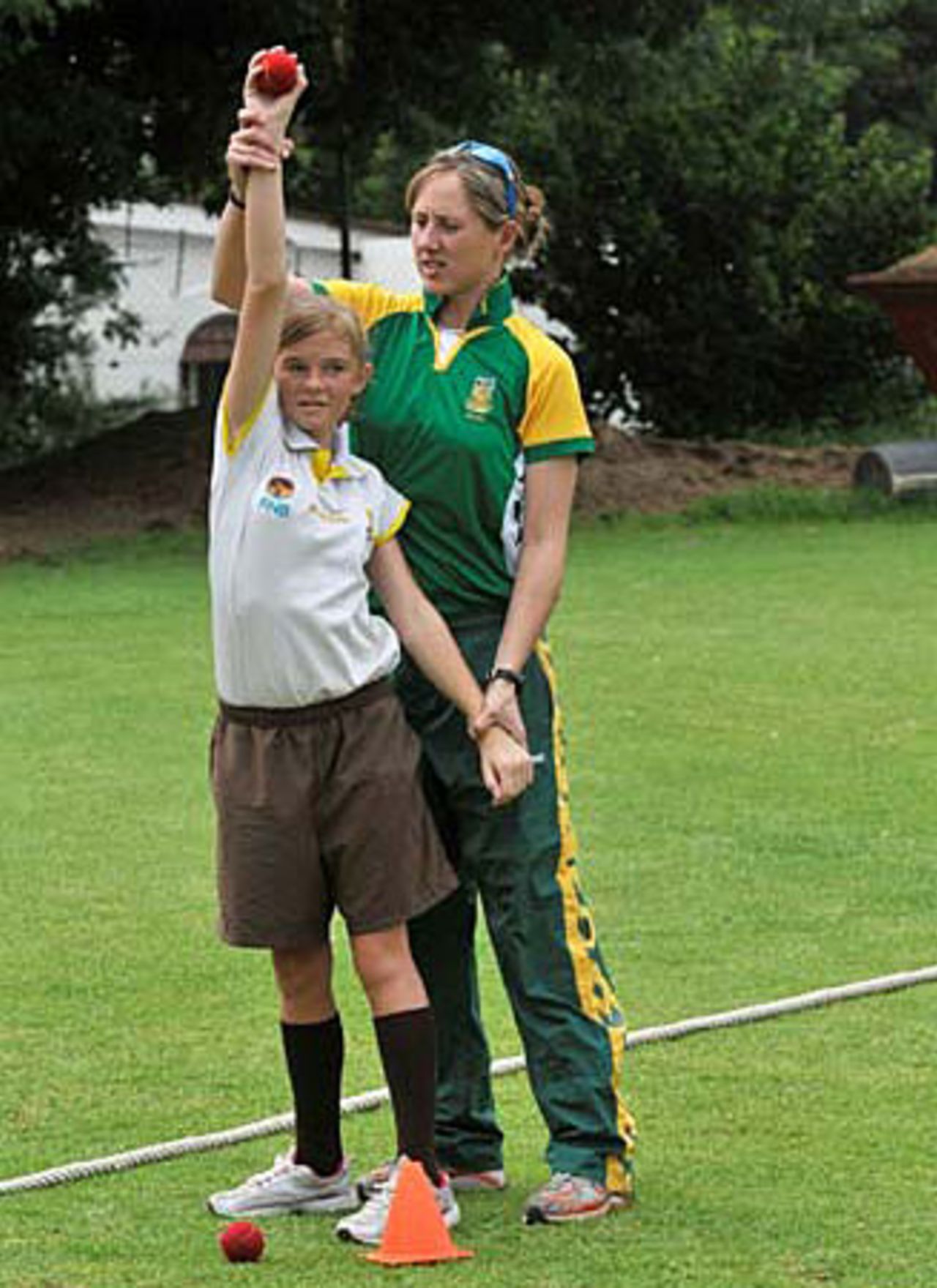 Cri-zelda Brits teaches a school girl how to bowl, Johannesburg