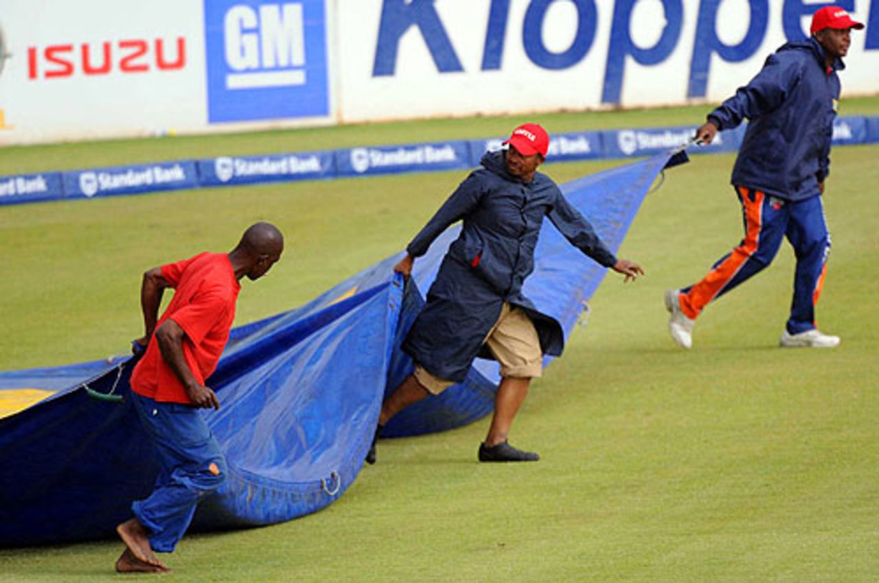 The groundstaff rush the covers on as rain halts play on the third day at Bloemfontein, South Africa v Bangladesh, 1st Test, Bloemfontein, November 21, 2008