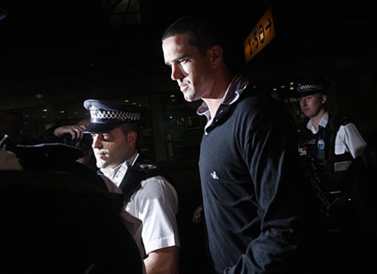 Police officers escort Kevin Pietersen out of Heathrow Airport, London, January 7, 2009