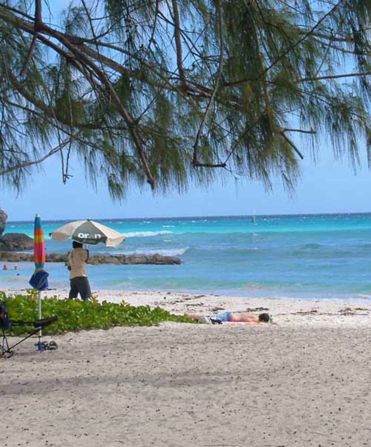 A tourist enjoys the sun on a Barbados beach, Barbados, February 21, 2009